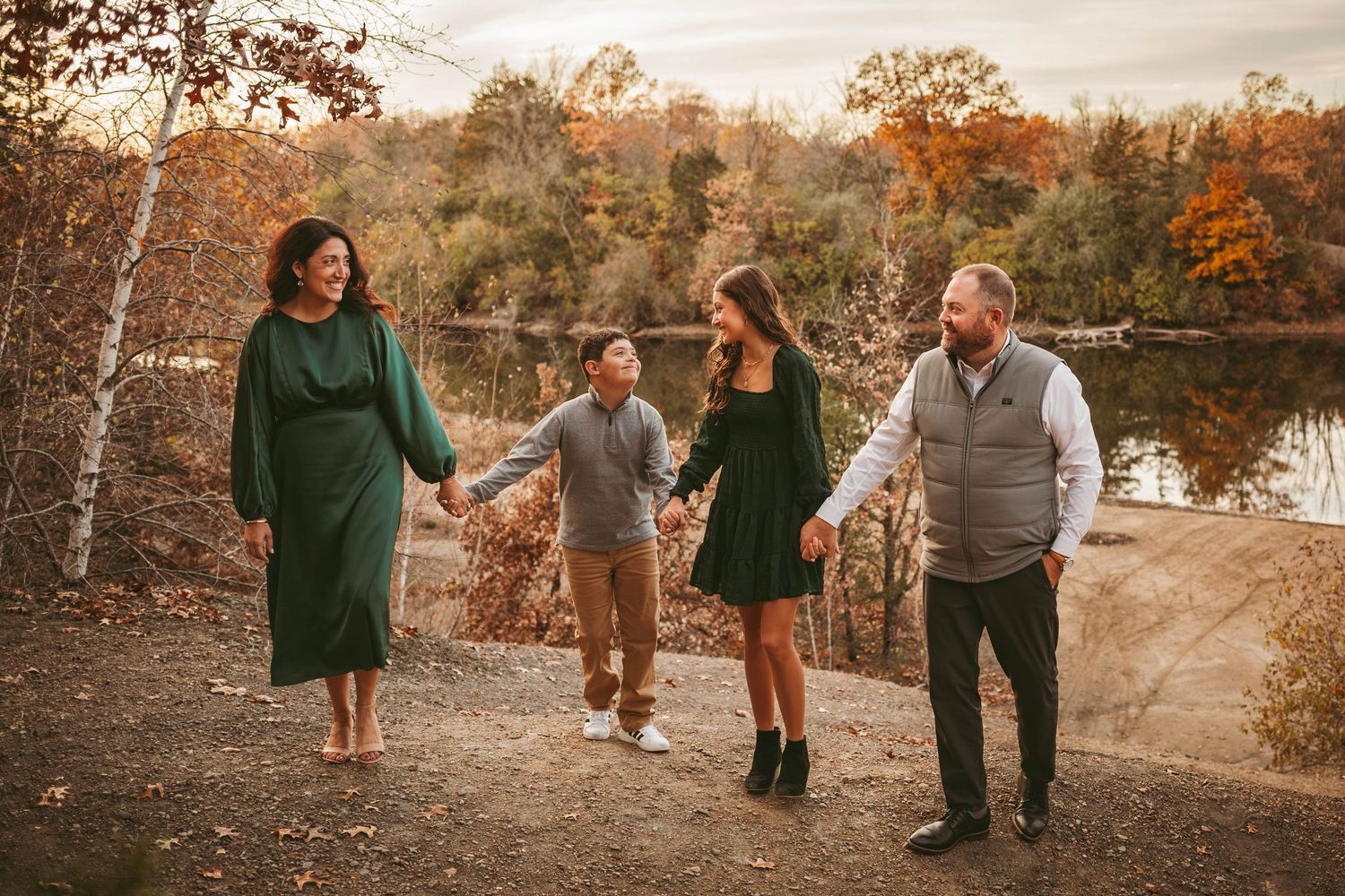 Family walks together in a Des Moines area park during sunset in the fall during a lifestyle family photo session.
