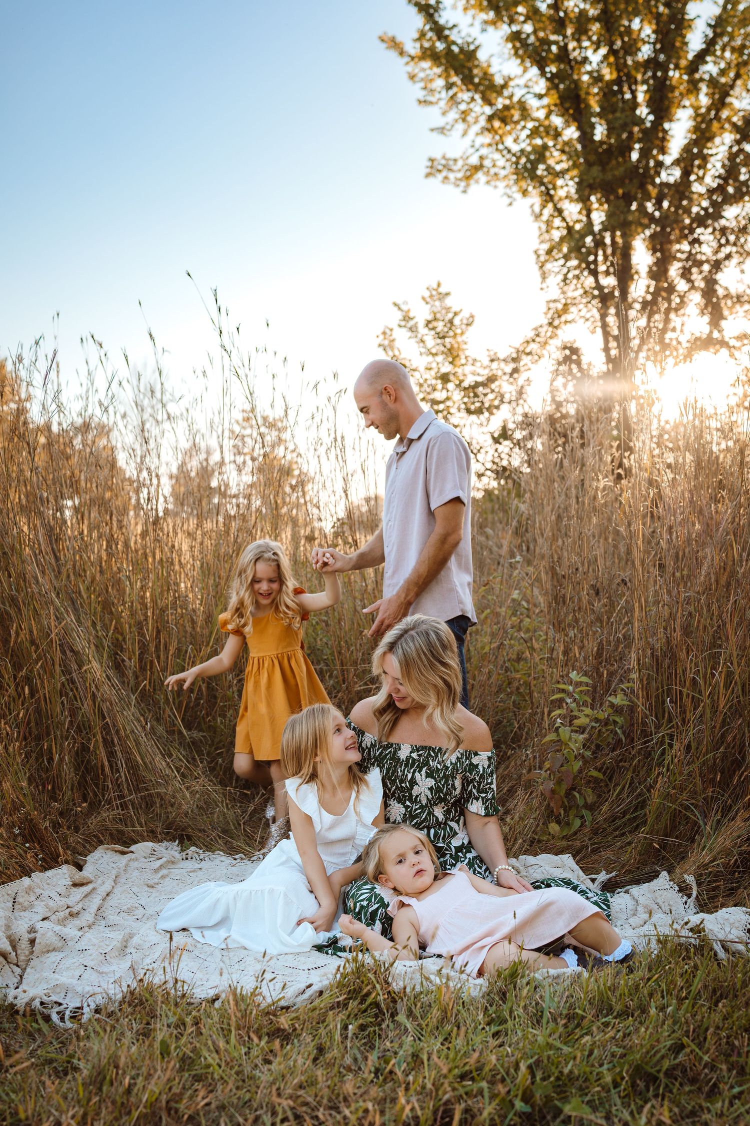 Family plays as in a Des Moines area park at sunset during a lifestyle family photo session.
