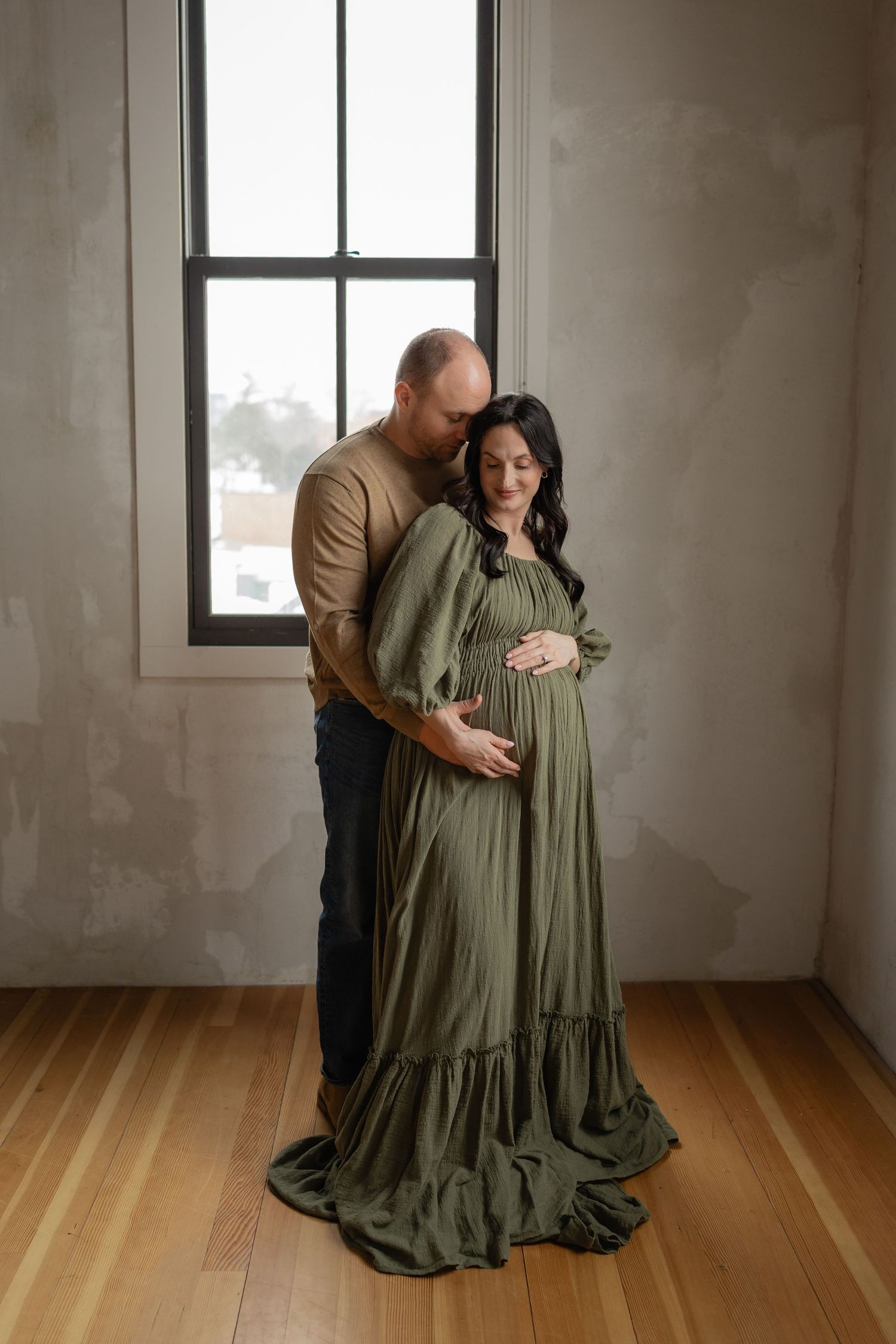 Pregnant woman and partner in a Des Moines studio during lifestyle maternity photo session.