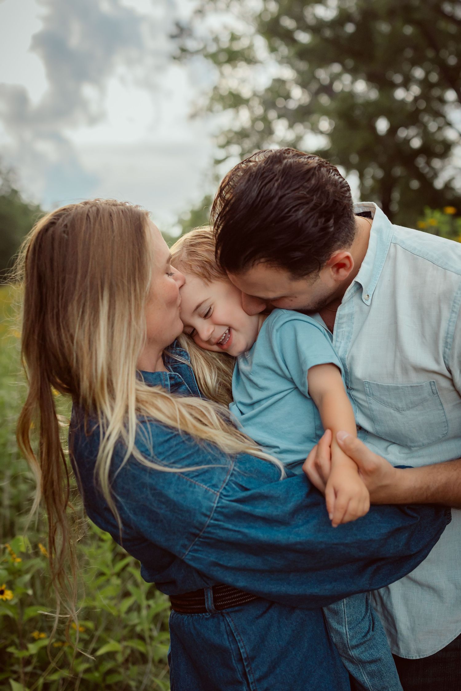 Family embraces in a Des Moines area park at sunset during a lifestyle family photo session.