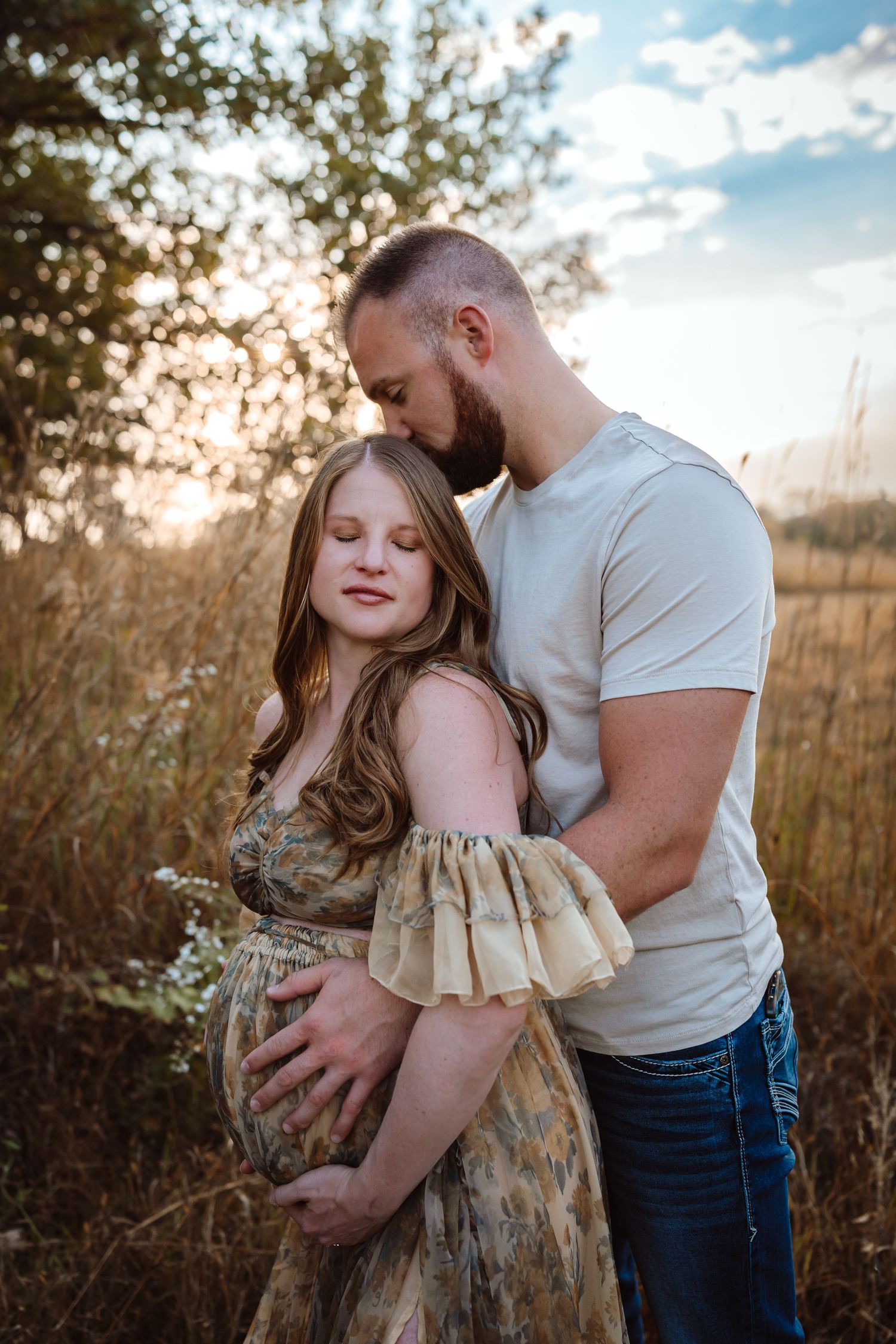 Pregnant woman in a Des Moines area field at sunset during lifestyle maternity photo session.