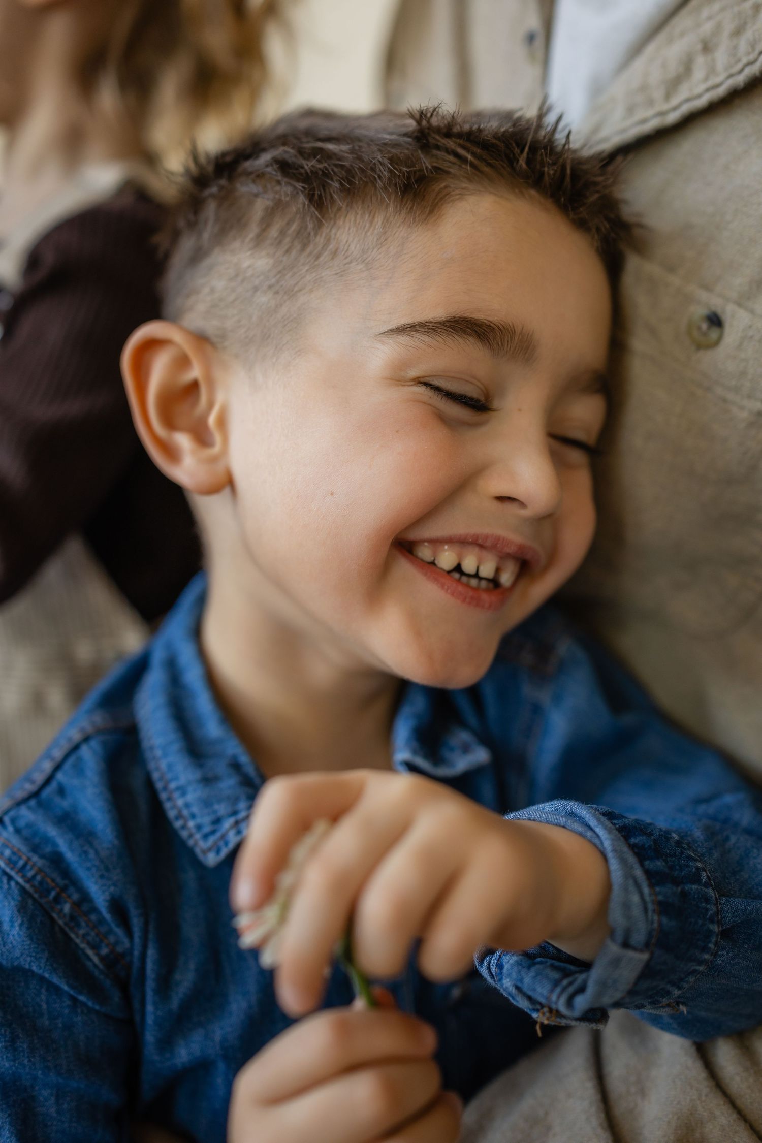 Boy snuggles dad with a big smile in a Des Moines area studio during a lifestyle family photo session.