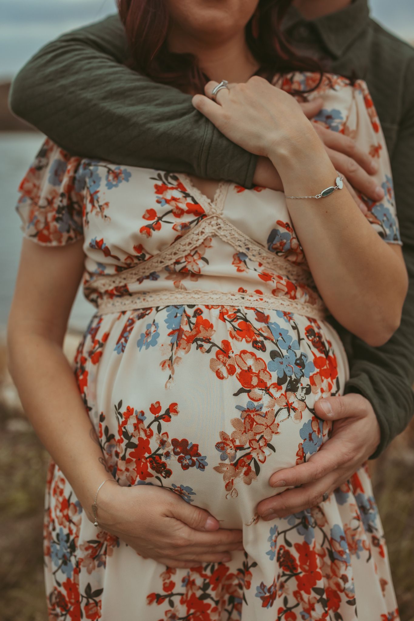 Pregnant woman and partner in a Des Moines field during lifestyle maternity photo session.