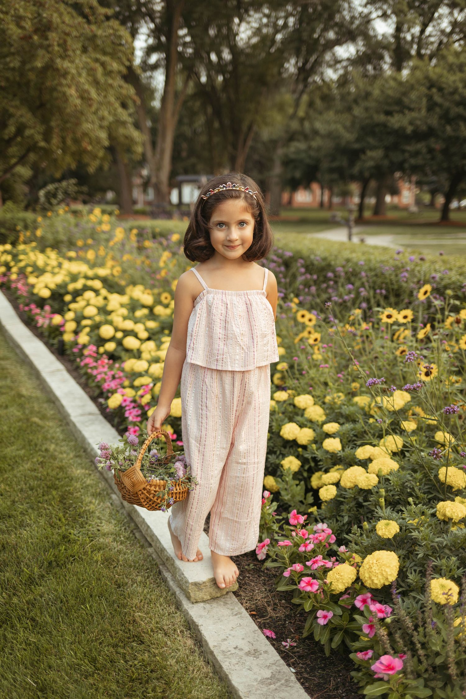 Young girl walks among the flowers in a Des Moines area park during a lifestyle family child milestone photo session.