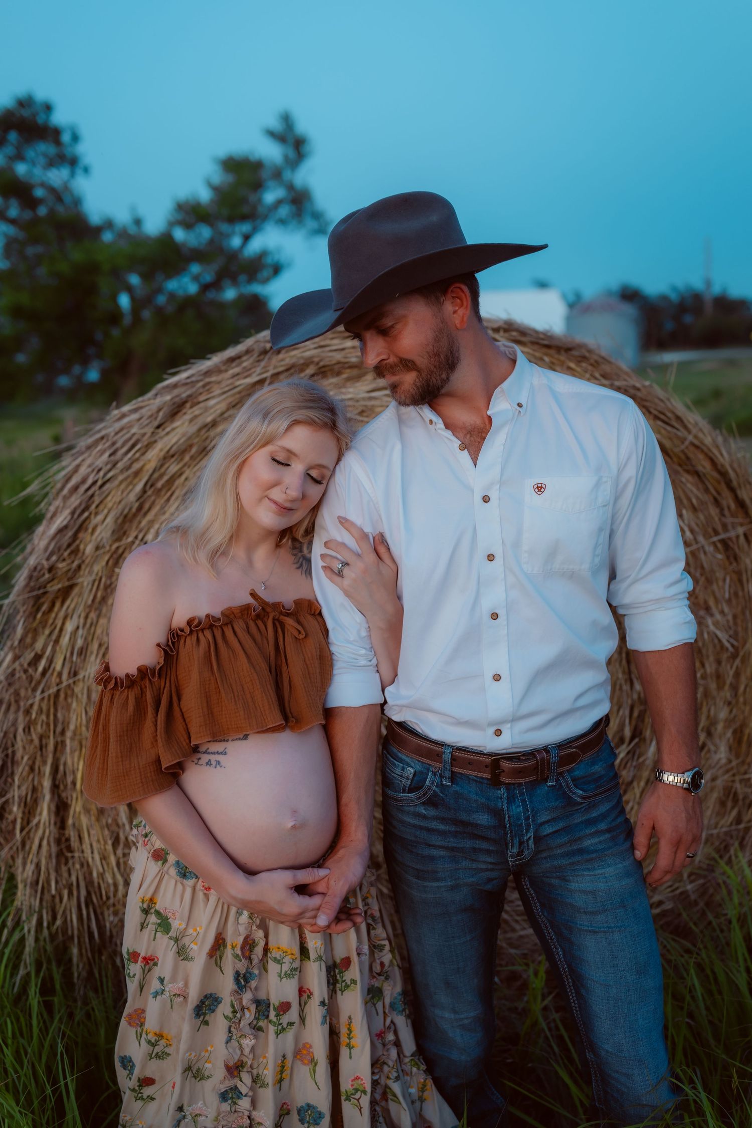 Pregnant woman in a Des Moines area field at sunset during lifestyle maternity photo session.