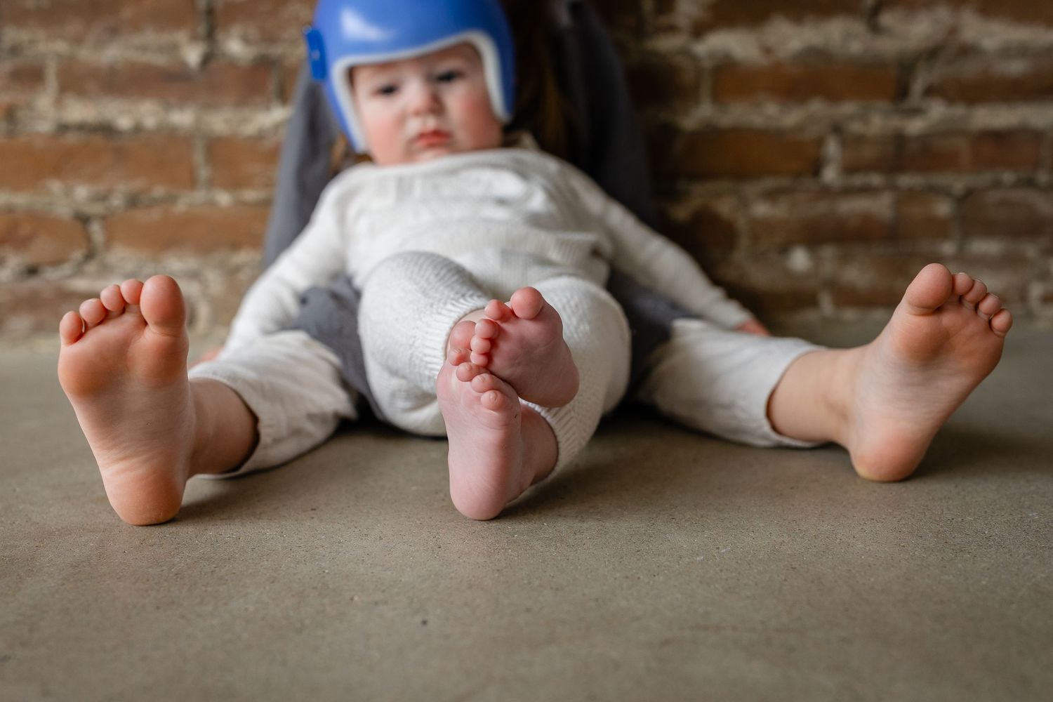 Baby brother and big sister's feet/toes in a Des Moines area studio during a lifestyle family child milestone photo session.