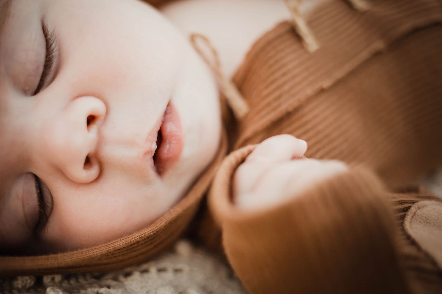Image focuses on baby's facial features in a Des Moines area park during a lifestyle child milestone photo session.