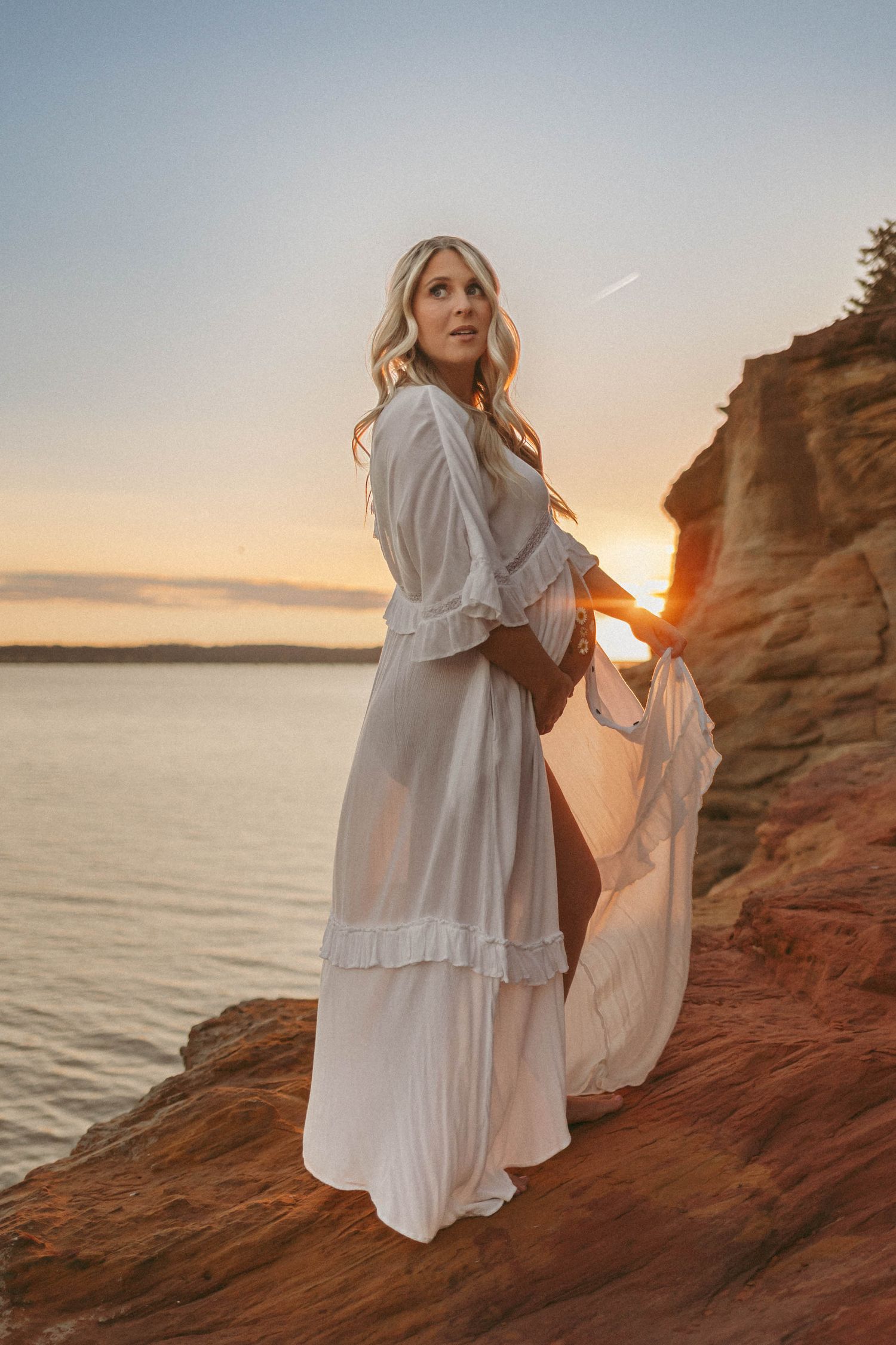 Pregnant woman in a Des Moines area lake at sunset during lifestyle maternity photo session.