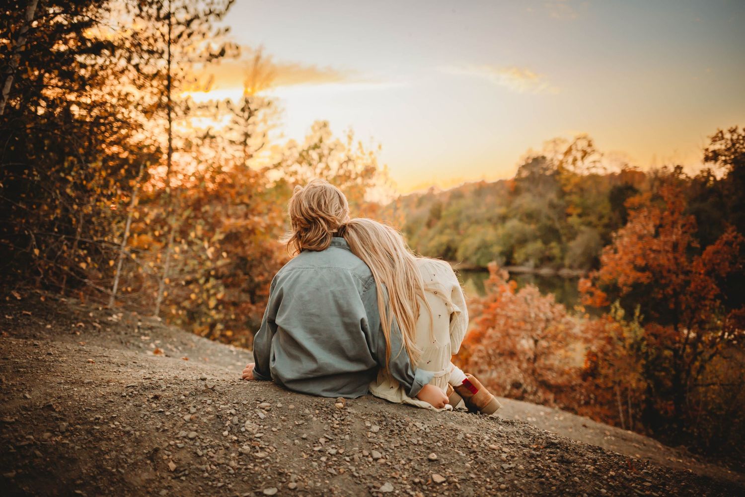Young girl rests head on brother's shoulder in a Des Moines area park at sunset during a lifestyle family child milestone photo session.