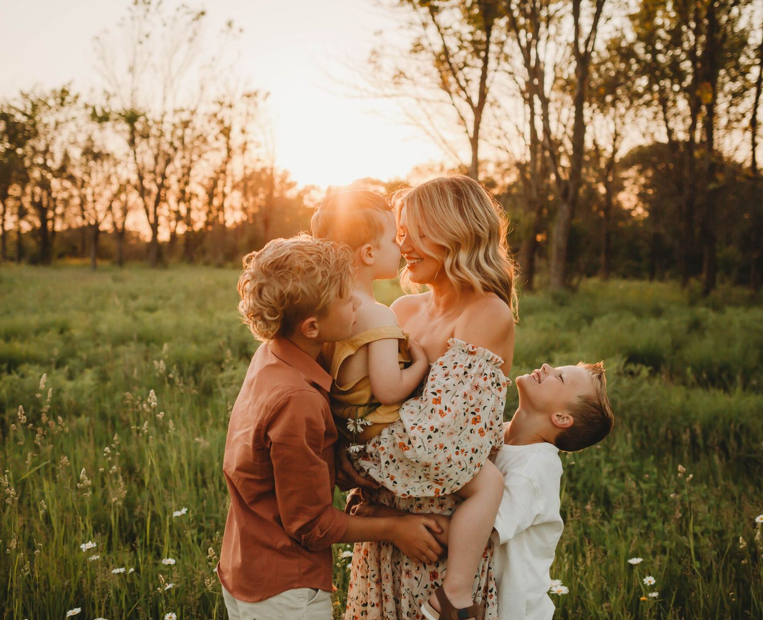 Children snuggle mom in a Des Moines area park at sunset during a lifestyle family photo session.