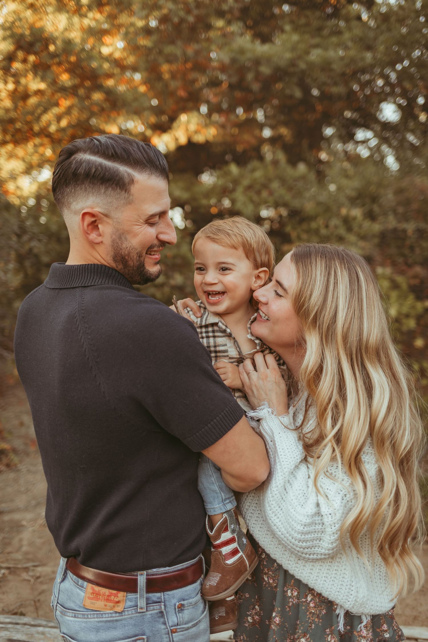 Family embraces in a Des Moines area park during a lifestyle family photo session.
