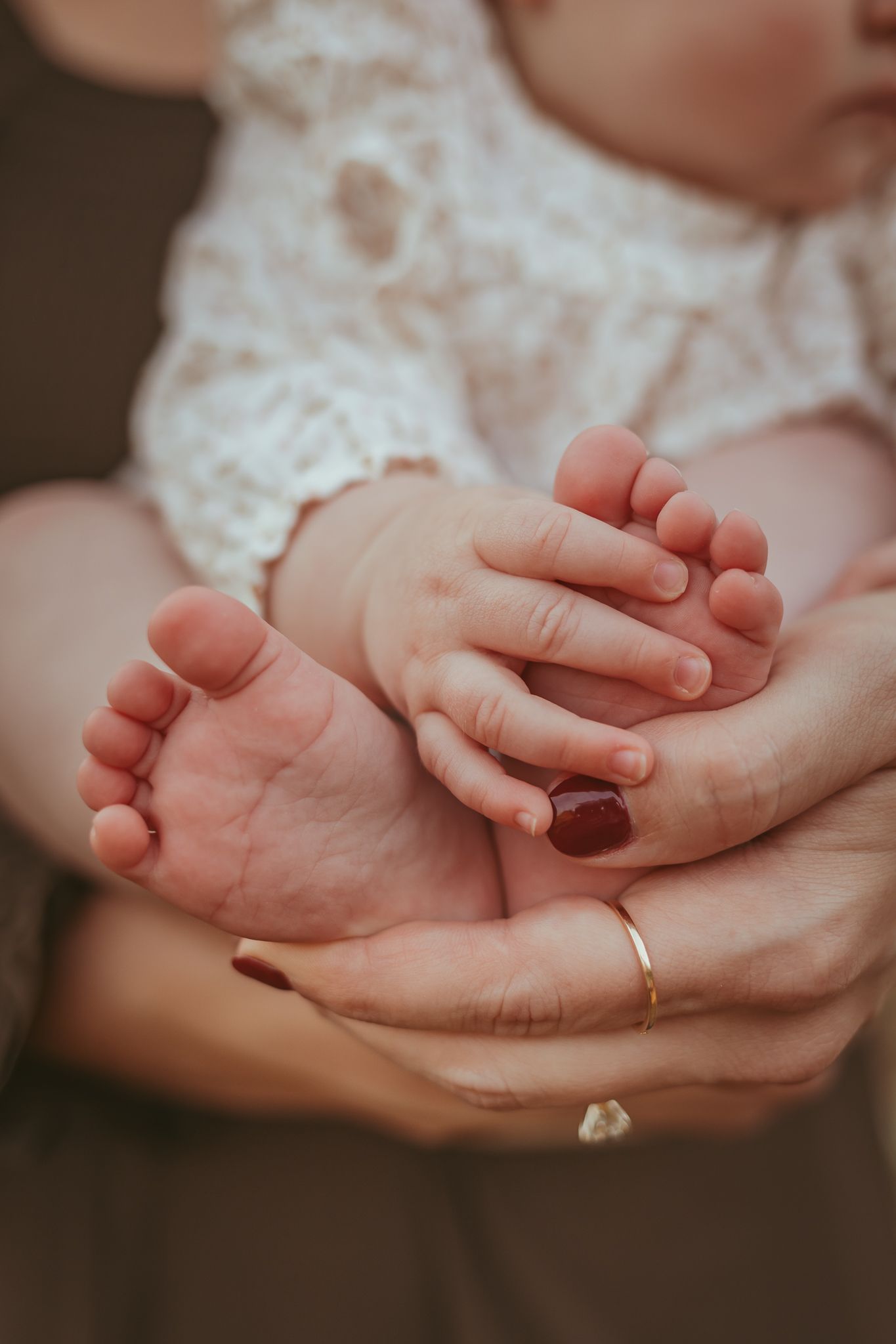 Baby girl holds toes in a Des Moines area park at sunset during a lifestyle family child milestone photo session.
