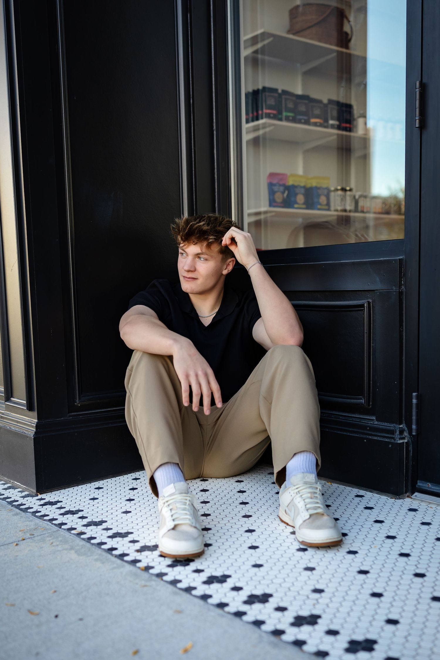High school senior boy poses in an urban setting in the Des Moines area during a lifestyle senior photo session.