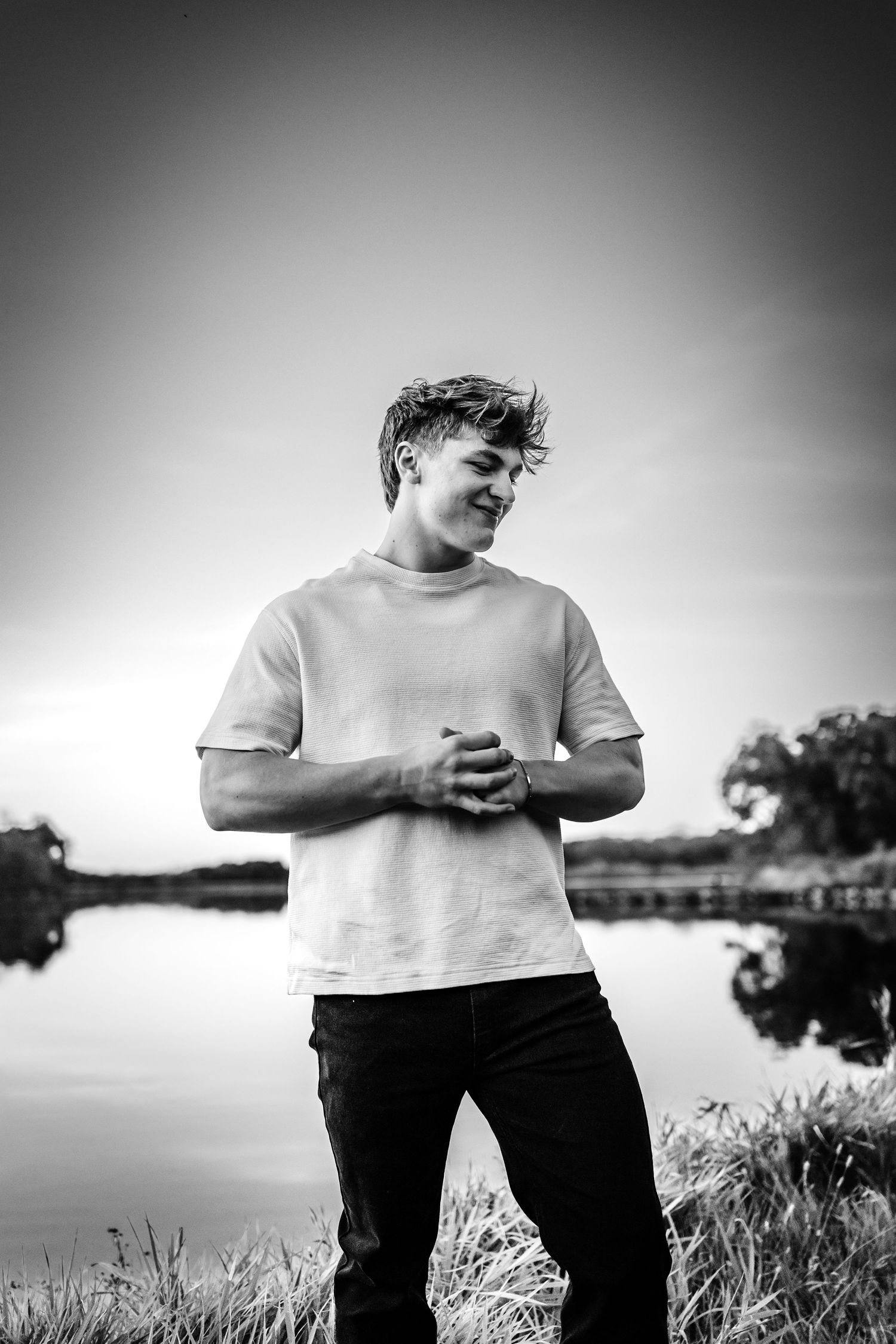 High school senior boy poses in a Des Moines area park during a lifestyle senior photo session.