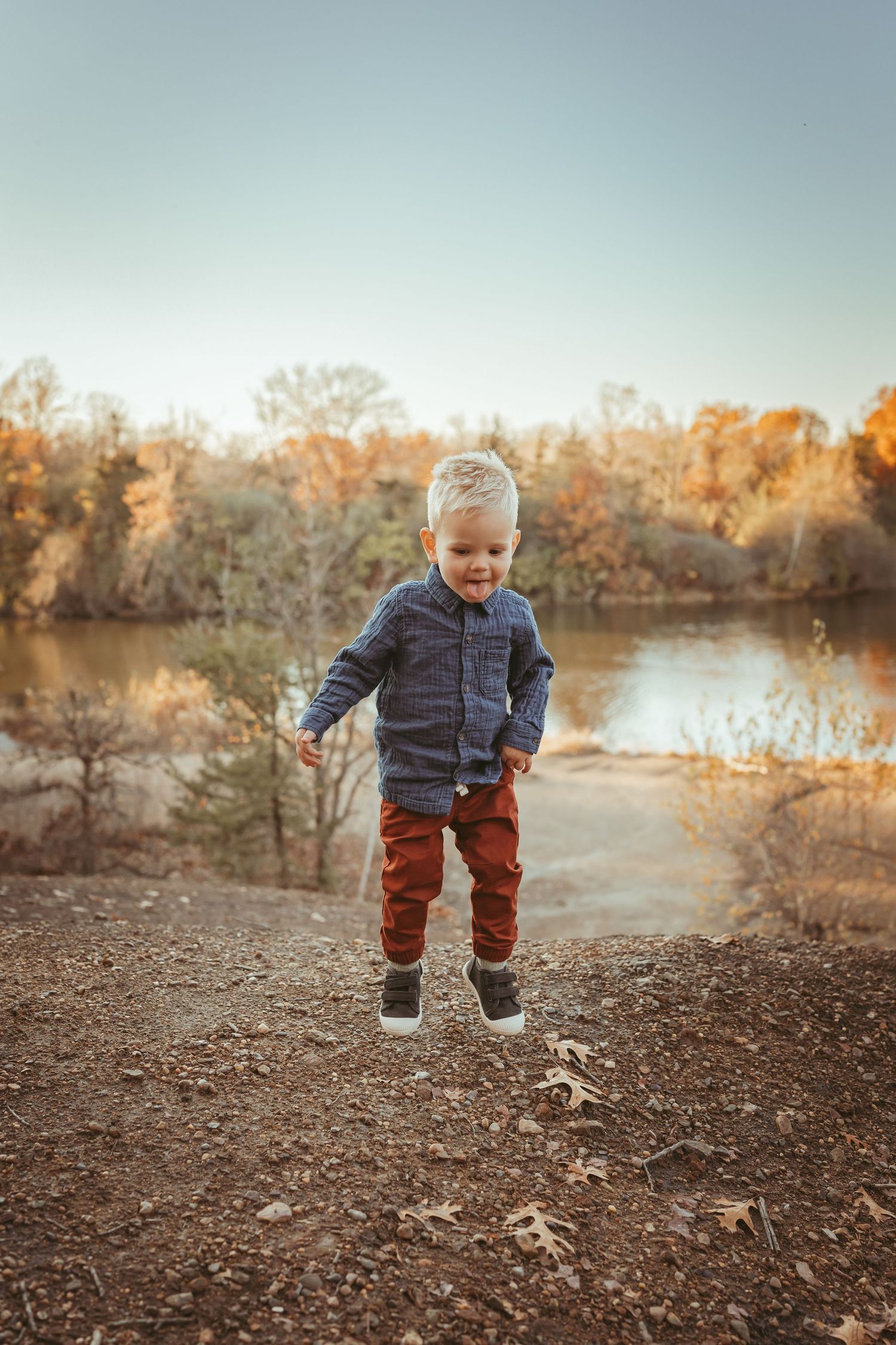 Young boy jumps in air in a Des Moines area park during a lifestyle family photo session.