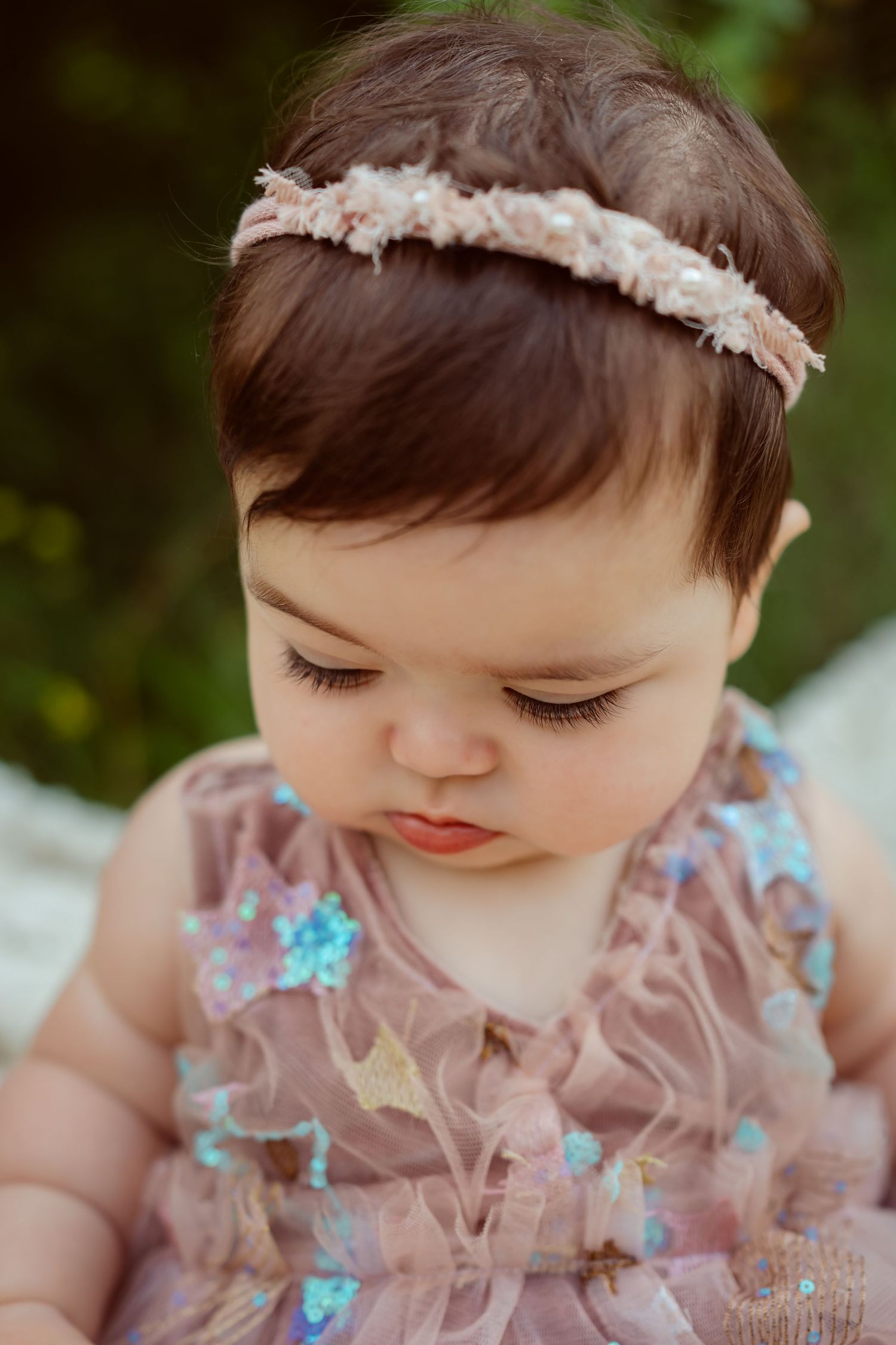 Close of up baby girl's face in a Des Moines area park during a lifestyle family child milestone photo session.