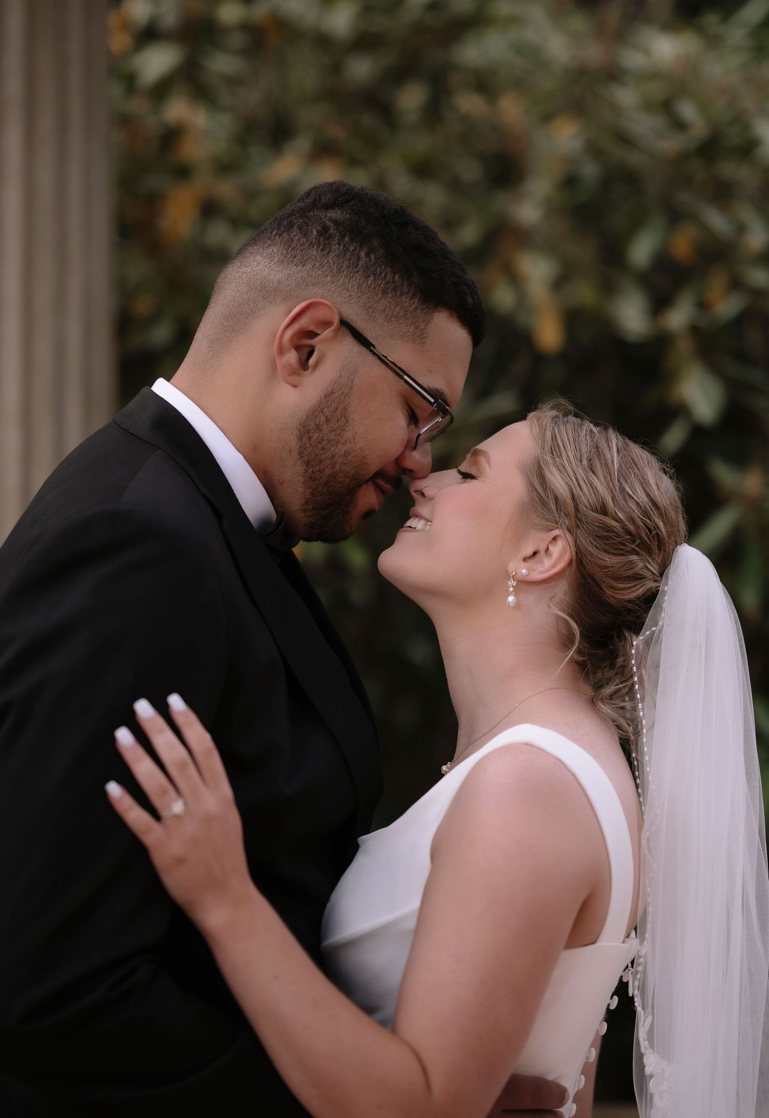 A romantic sequence of wedding photos shows a couple sharing an intimate kiss against a natural outdoor backdrop.