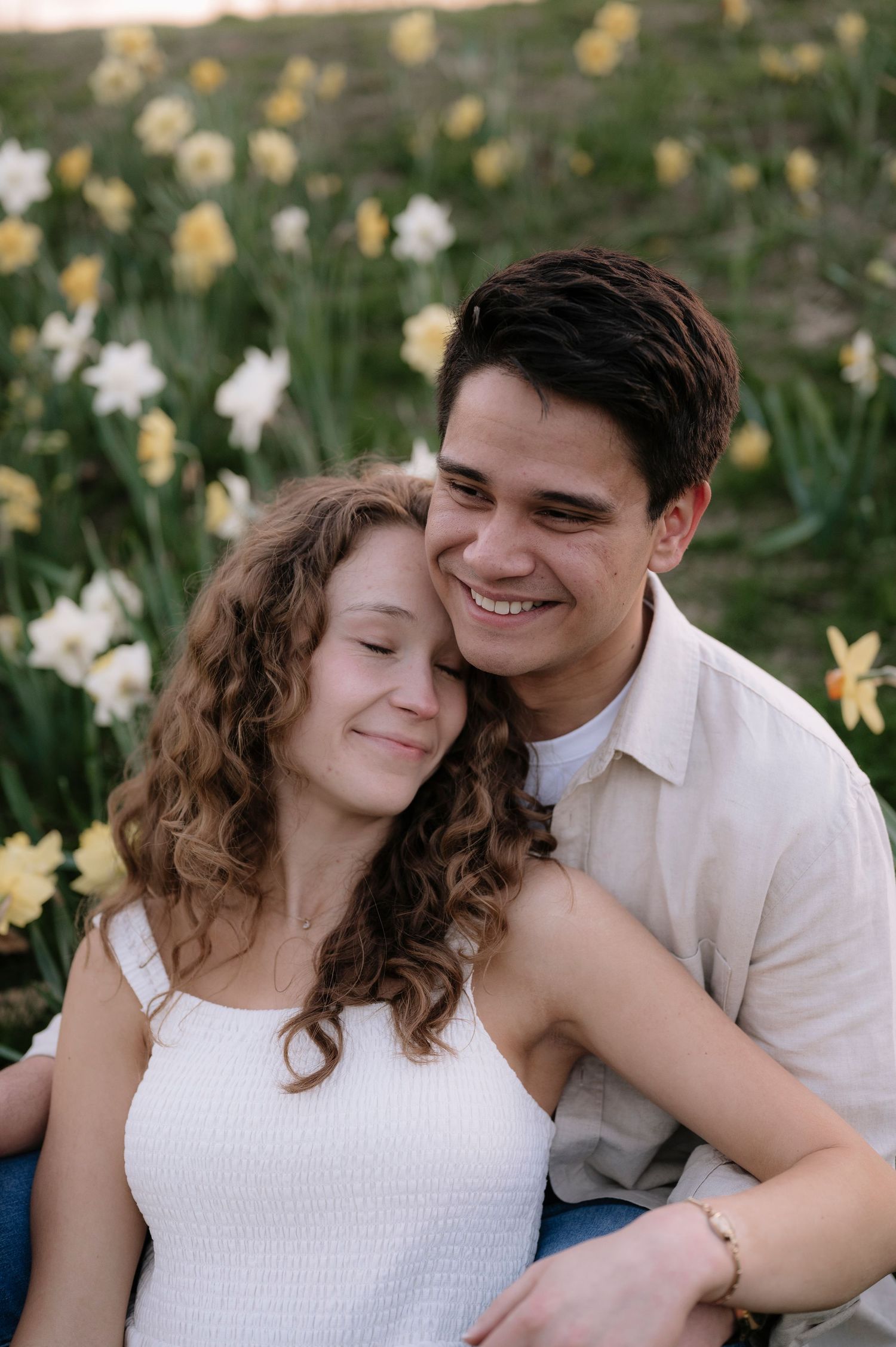 Tender moment shared among blooming spring daffodils in garden setting.