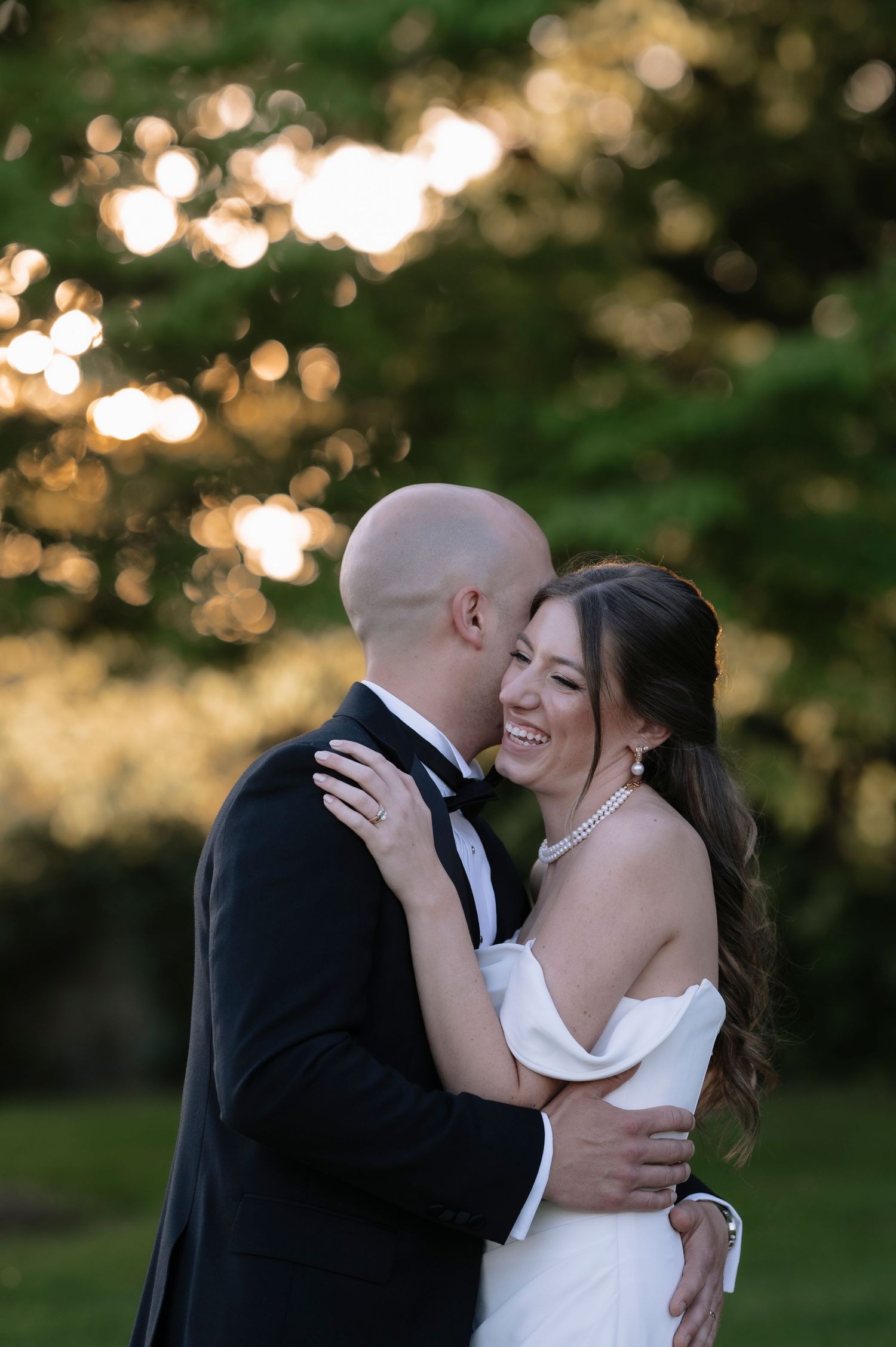 A romantic sunset photo series shows a couple sharing an intimate kiss in their wedding attire on their special day.