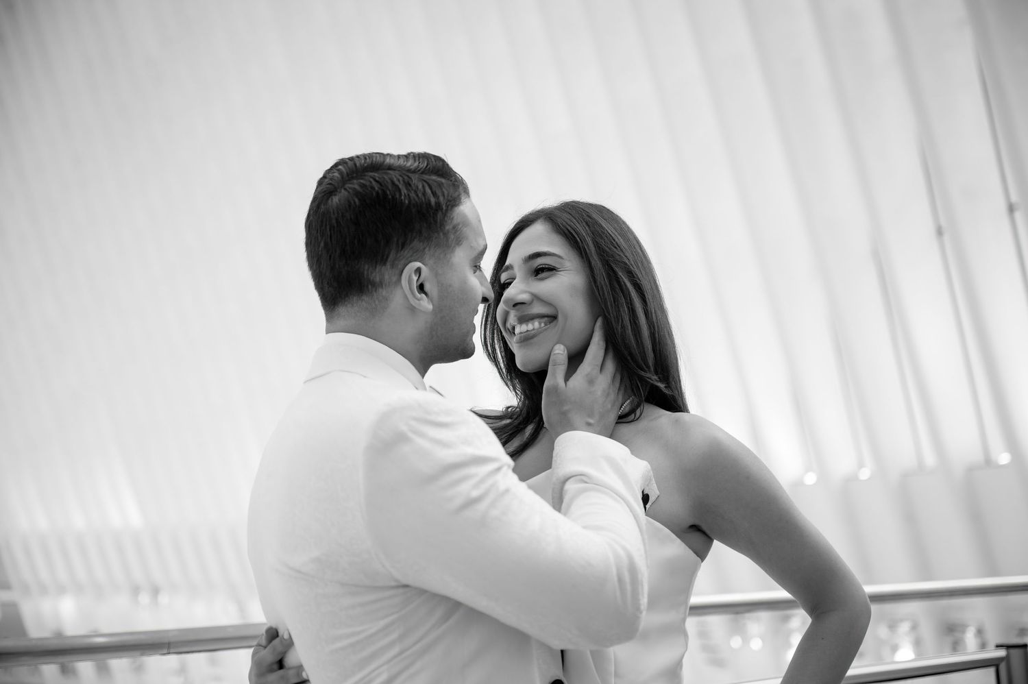 A happy couple shares a joyful intimate moment together in black and white photography.