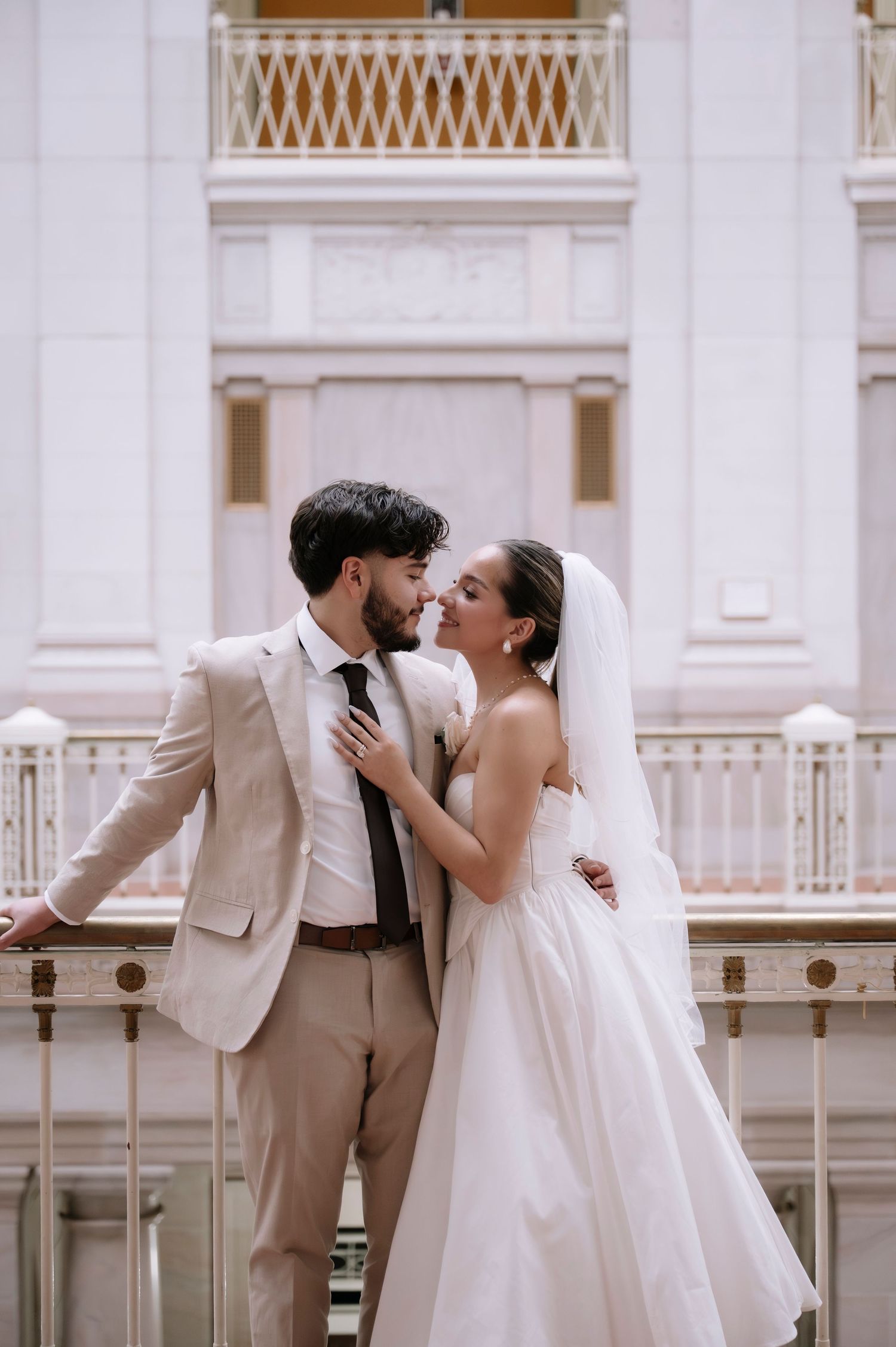 A romantic wedding couple shares intimate moments in a series of elegant architectural photos.