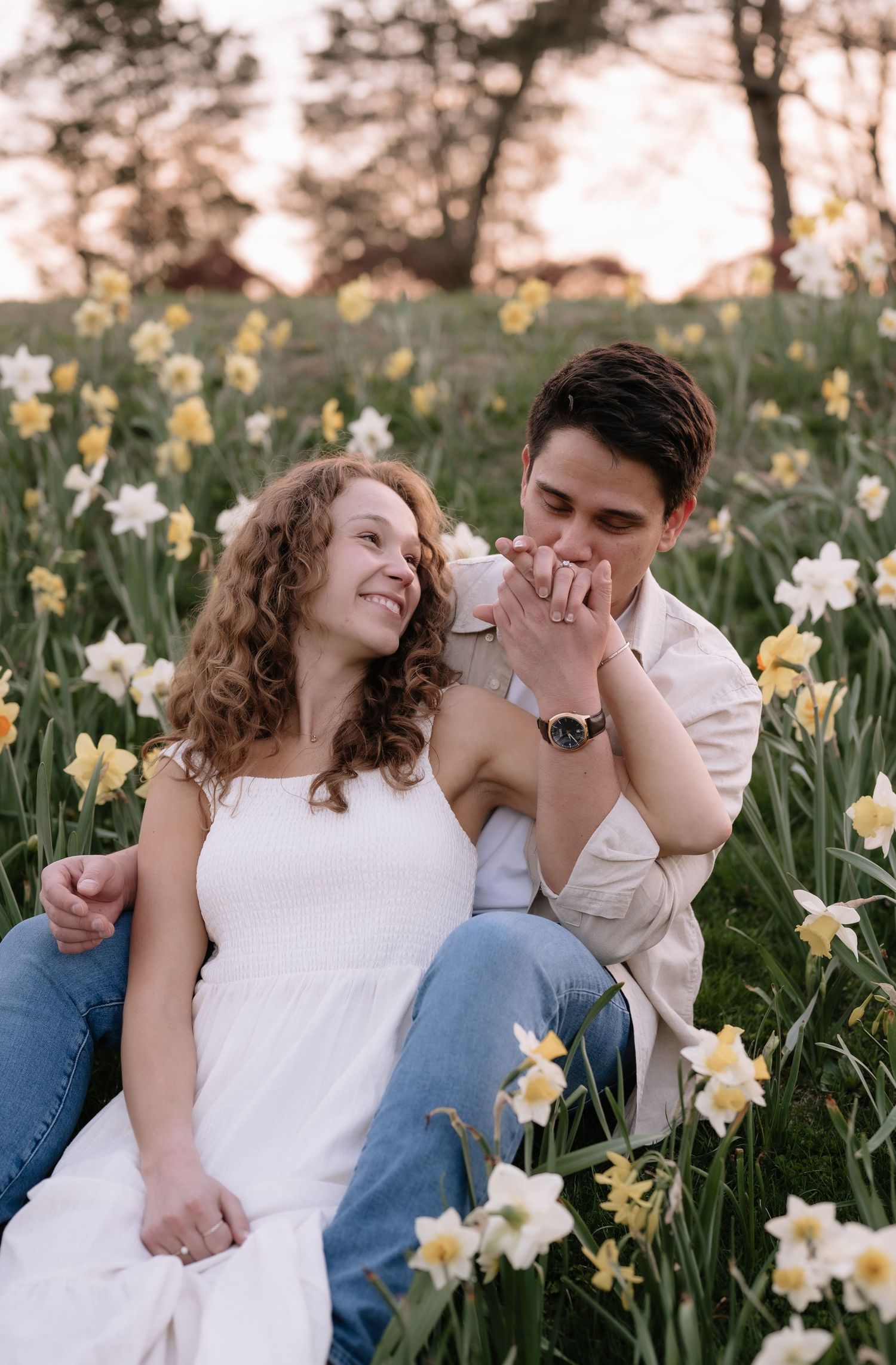 A romantic moment shared in a field of blooming yellow daffodils during springtime.