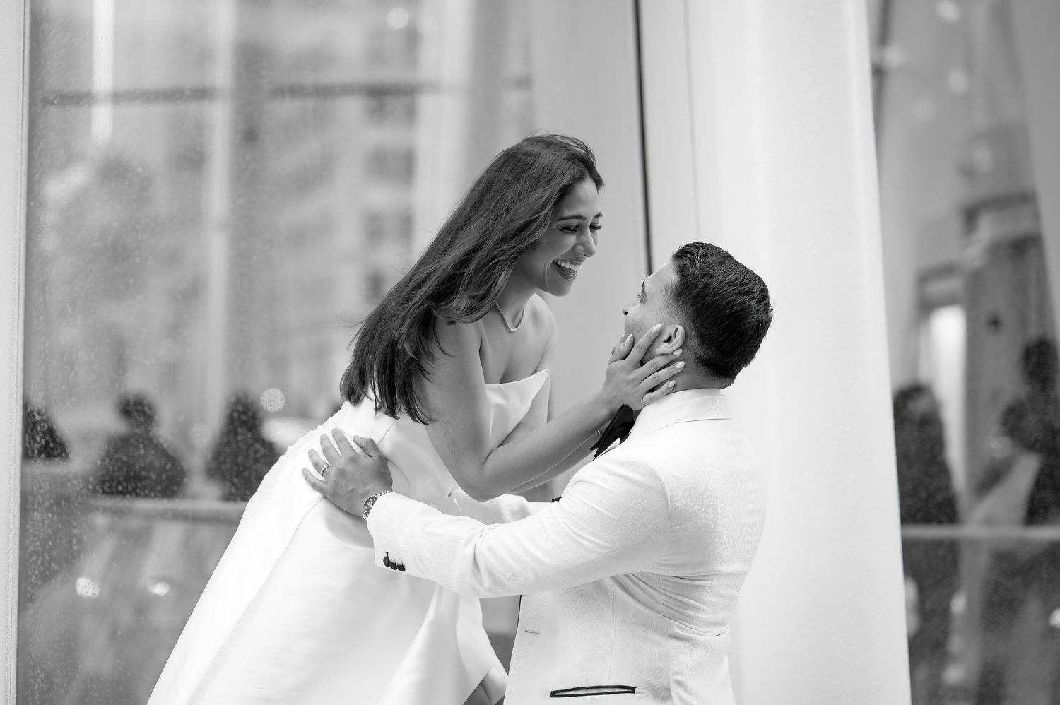 A romantic black and white capture of a couple sharing an intimate moment during what appears to be an engagement session.