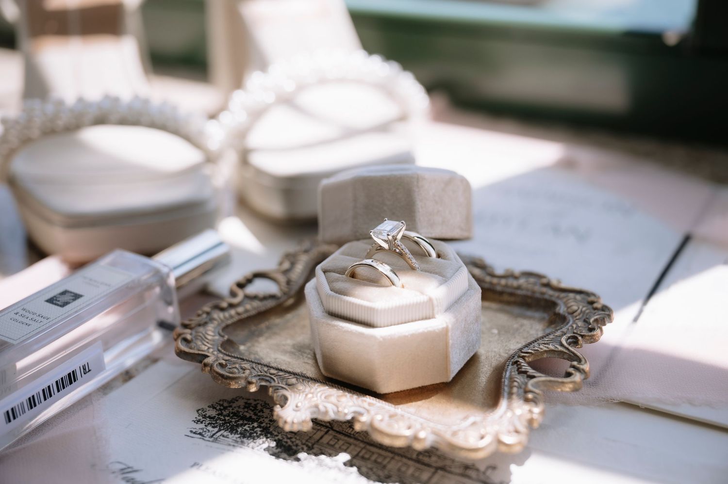 Ornate silver frames and decorative pieces arranged on a white table display vintage style accessories and design elements.
