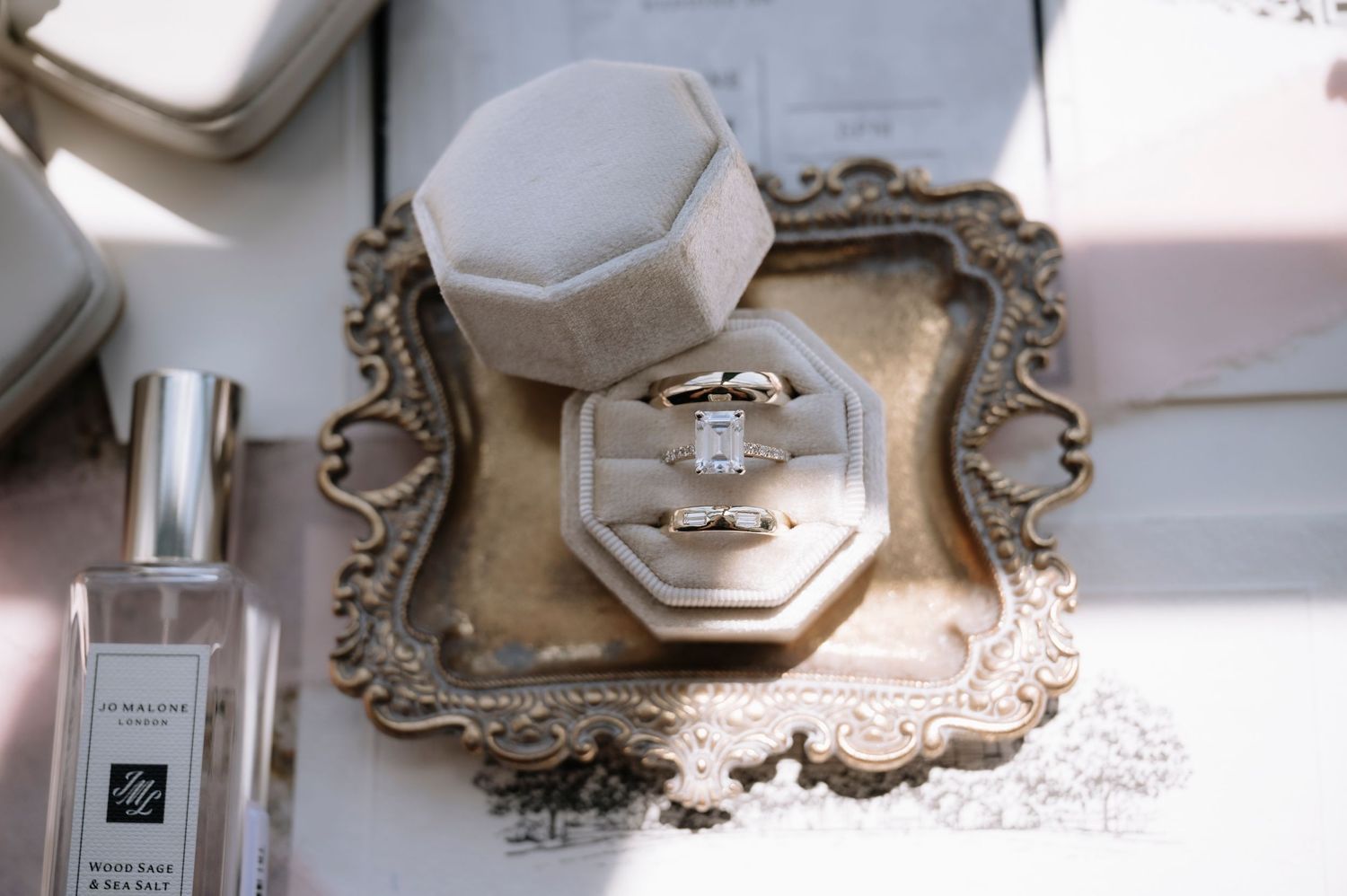 A vintage silver tray displays an engagement ring box next to a Jo Malone perfume bottle.