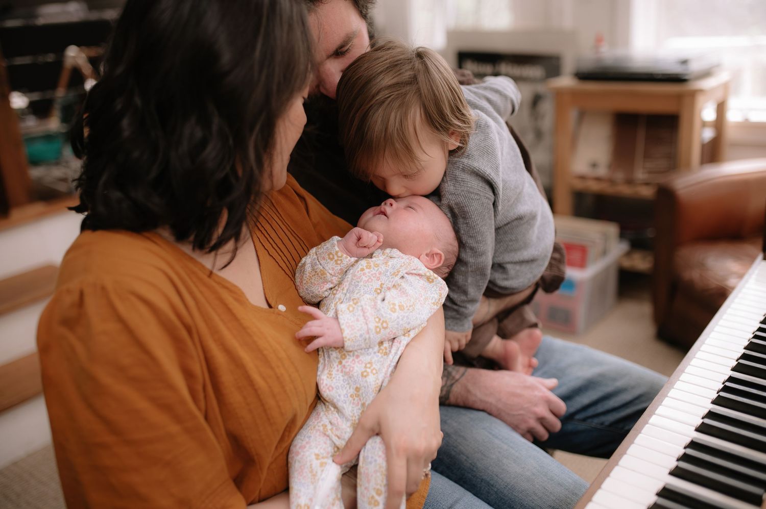 Family bonding over music at the piano with their children in a bright, cozy room.