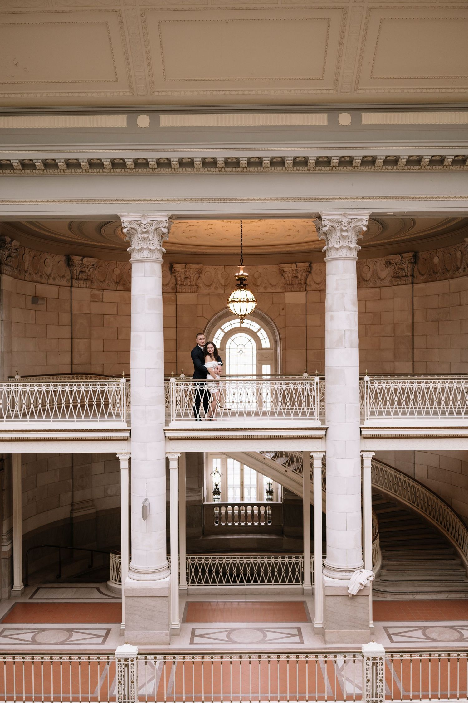 A grand interior architectural scene with ornate columns and balconies in a classical style building.