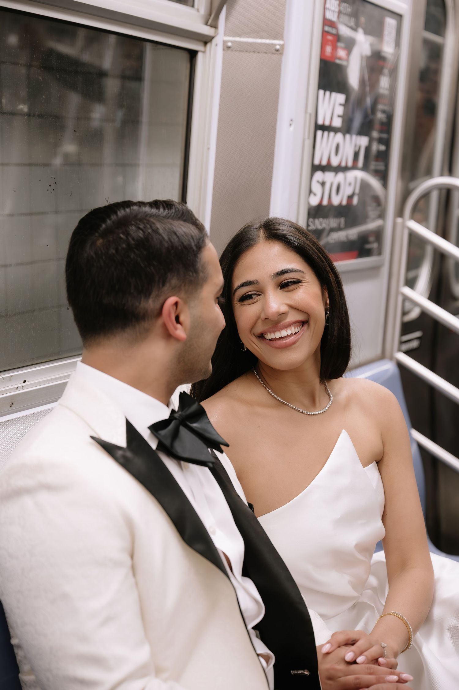 Candid moment of newlyweds laughing together on public transit.