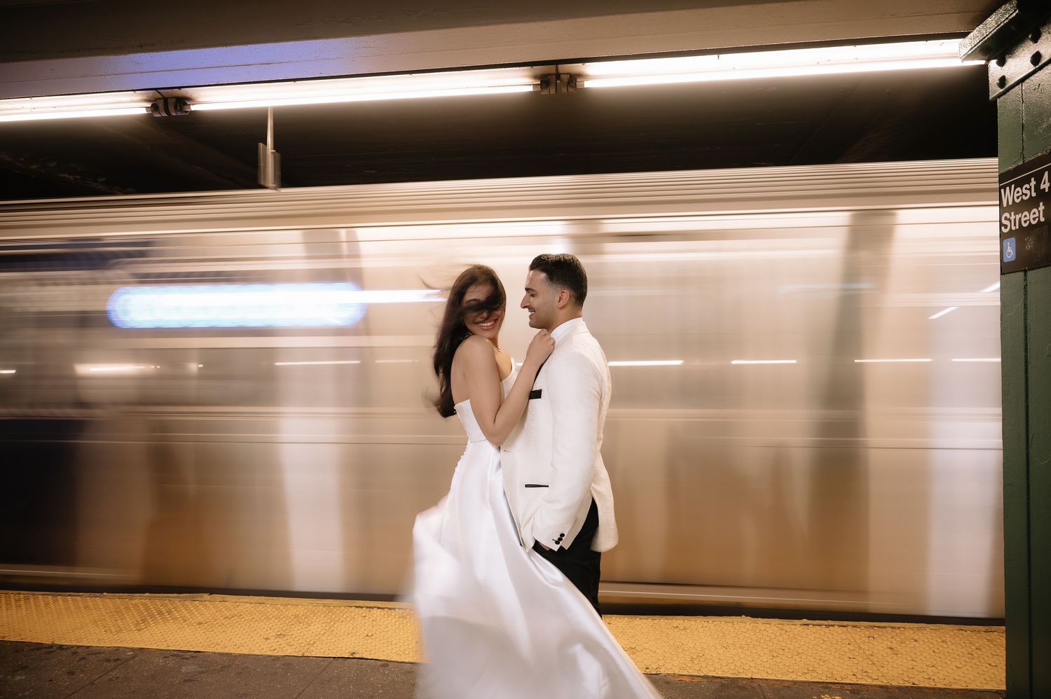 Artistic wedding photo with motion-blurred subway train in background.