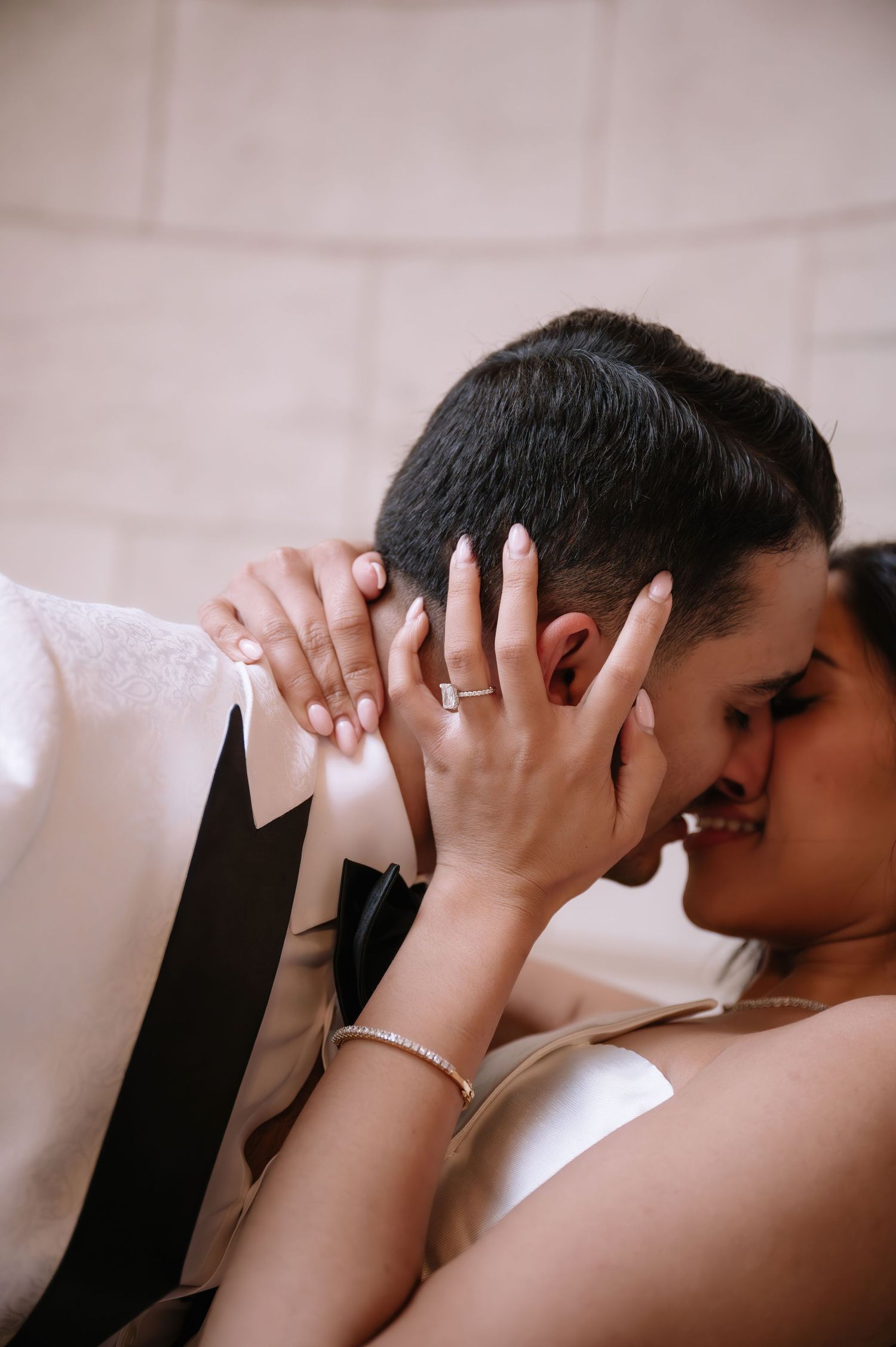Close up shot of a tender romantic moment with a couple embracing while showing off a diamond engagement ring.