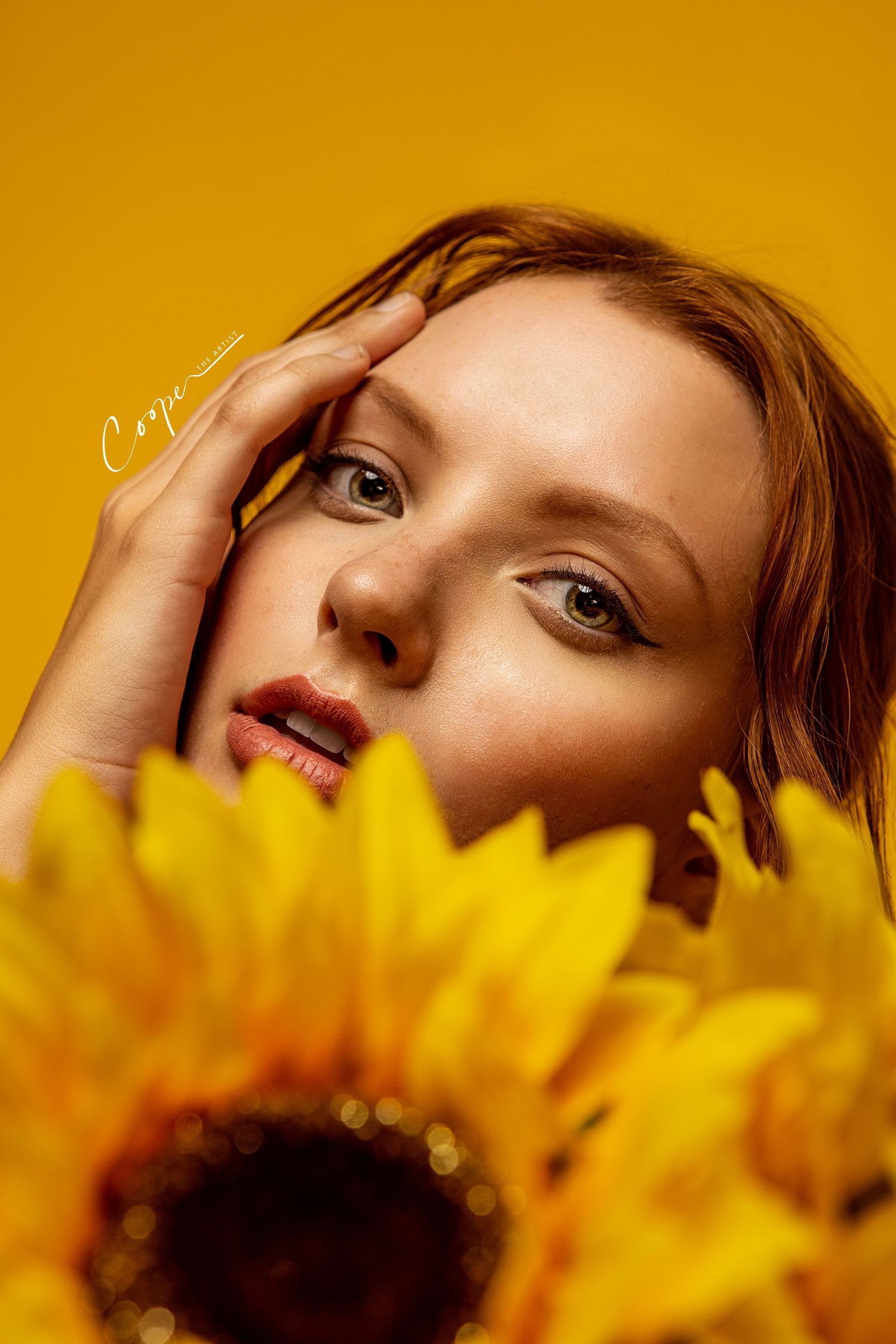 Artistic beauty portrait with sunflower against vibrant yellow background.