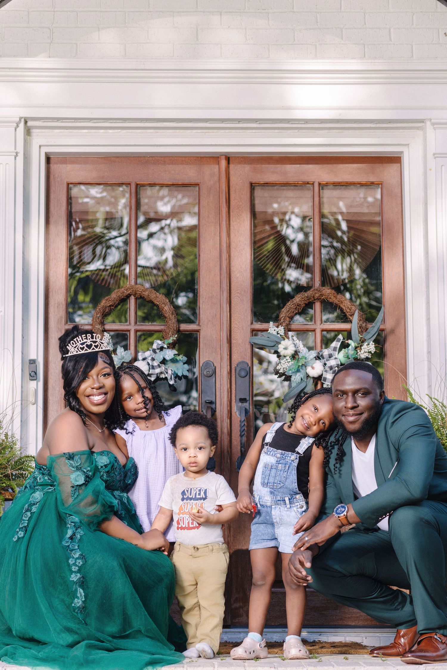 A family portrait on a doorstep with elegant decor and white French doors.