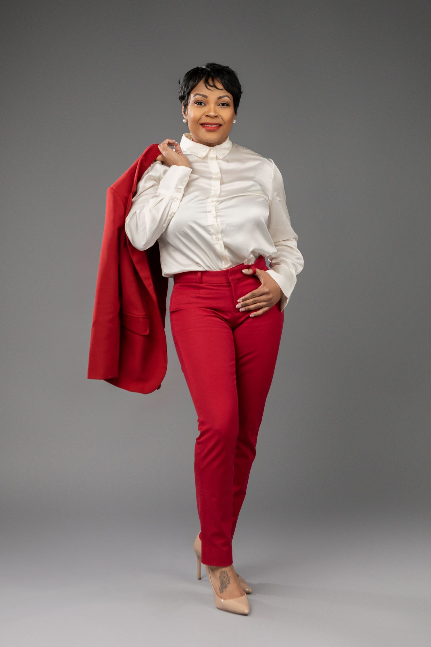 Stylish outfit featuring white button-up shirt paired with vibrant red pants and matching jacket.