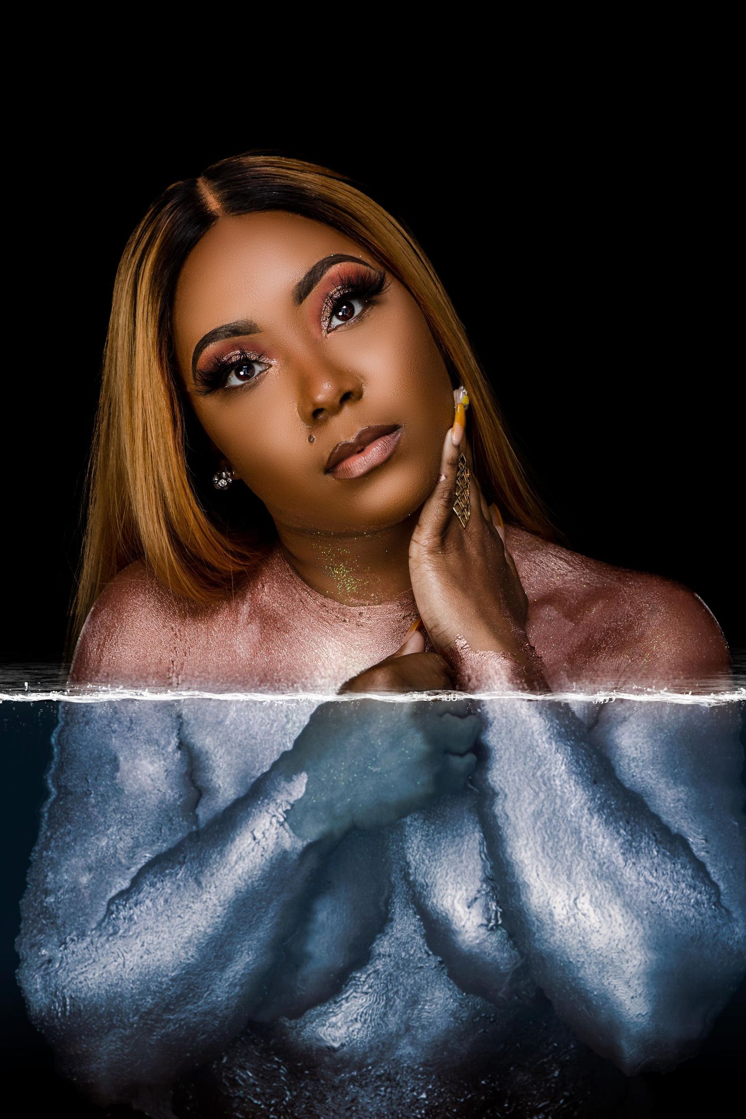 Creative portrait with dramatic lighting showing reflection effect against dark background.