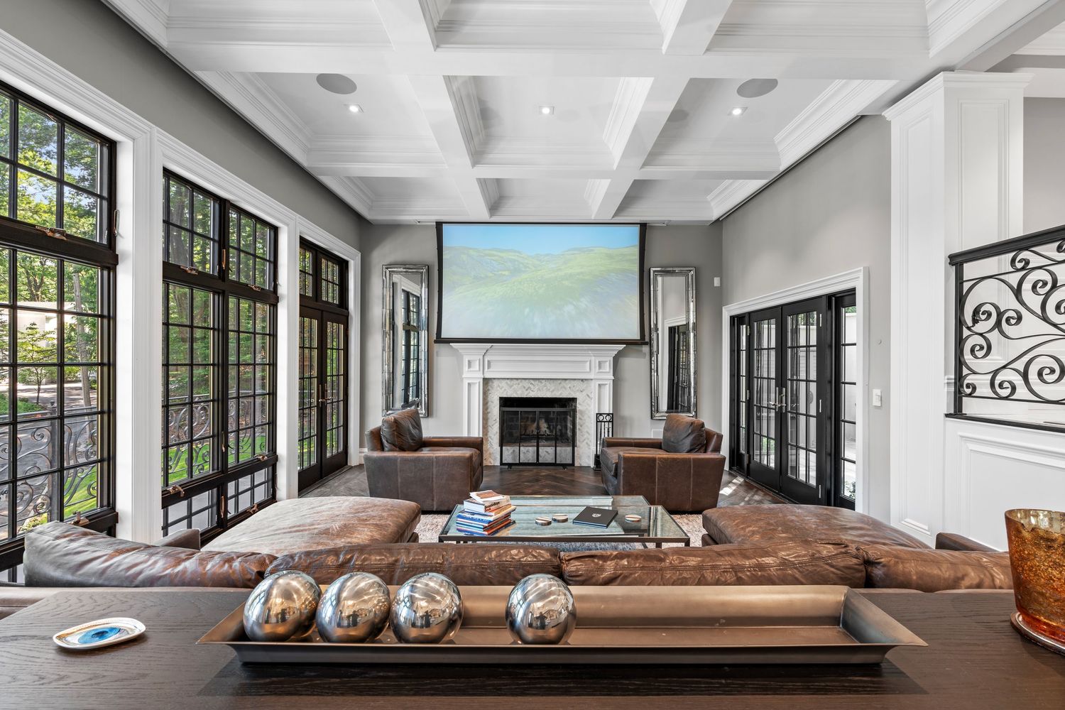 Modern open concept living room with coffered ceiling and large windows.