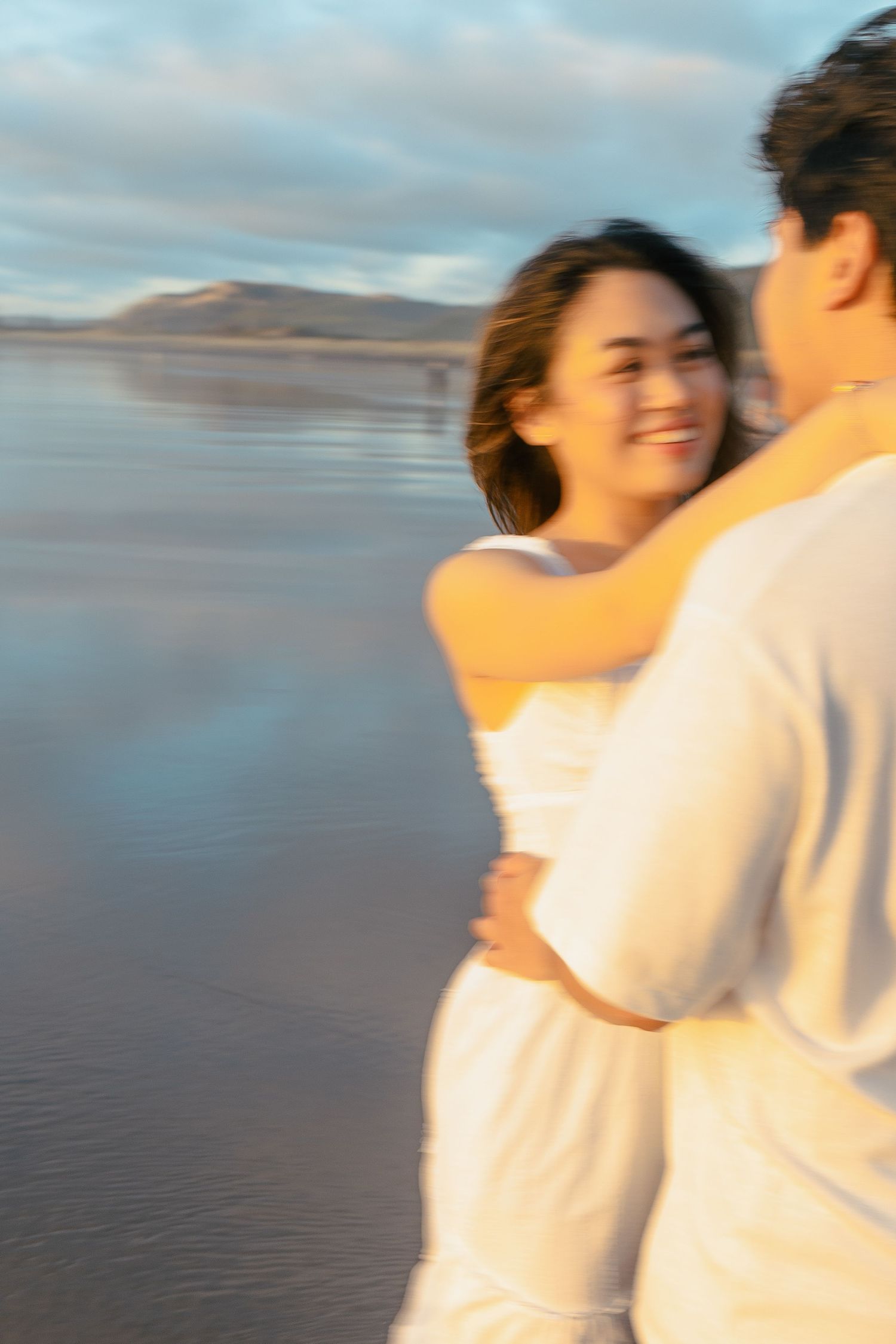 A couple photoshoot session during a magical sunset at Muriwai Beach by YM Photography.