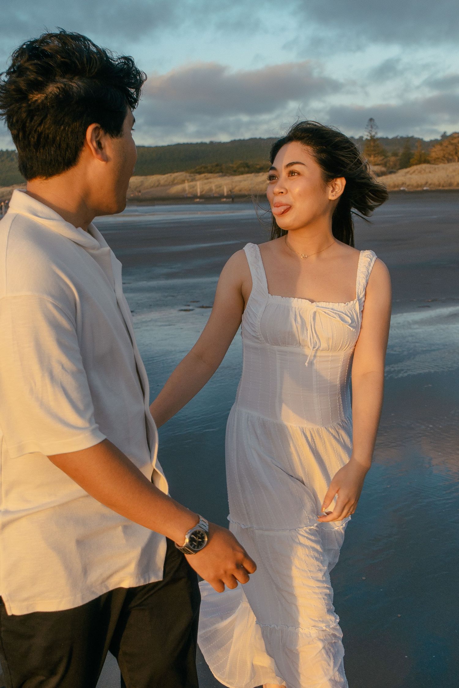 A couple photoshoot session during a magical sunset at Muriwai Beach by YM Photography.