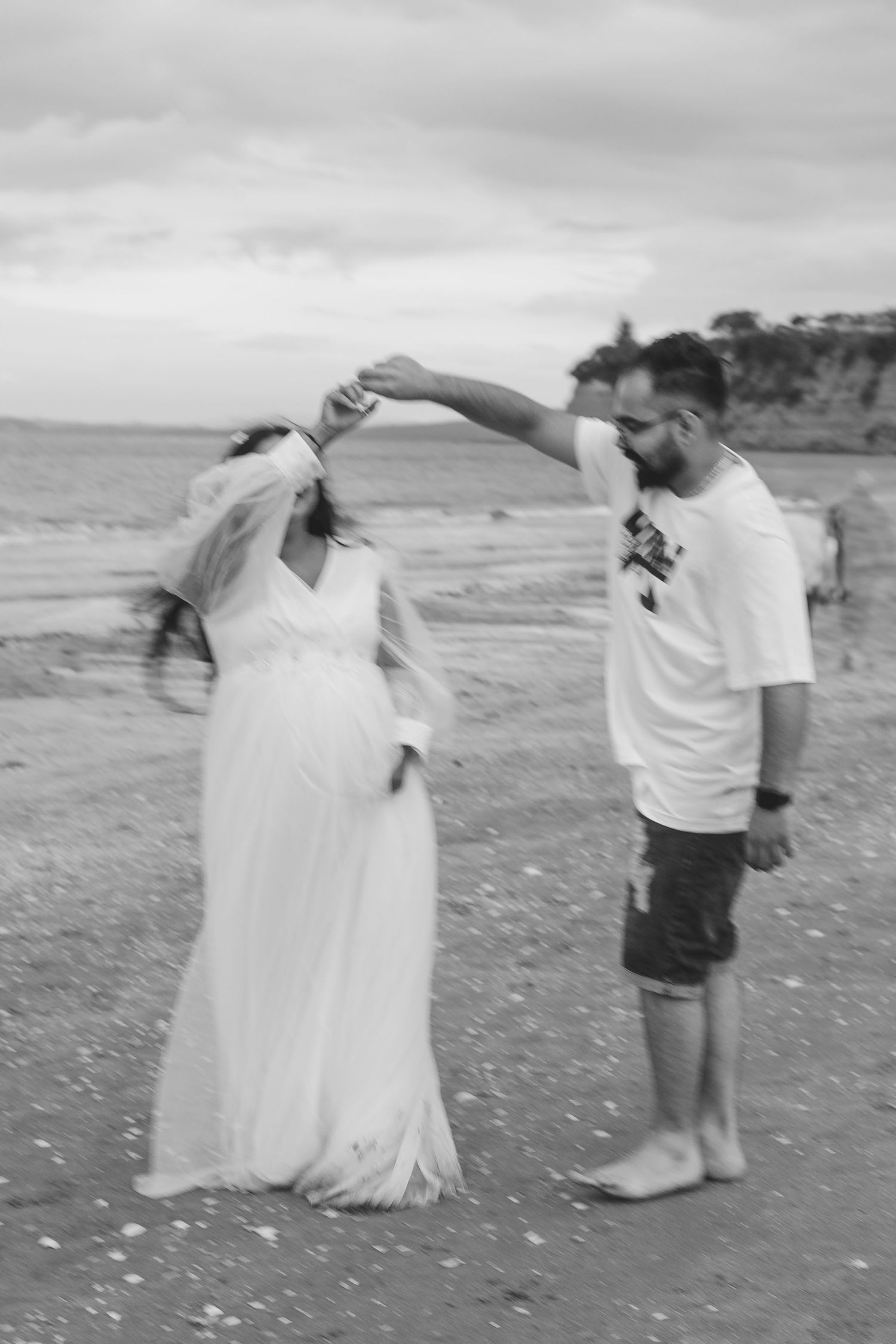 A gorgeous maternity shoot during sunset at Long Bay Beach, Auckland by YM Photography. White, flowy maternity dress used from Shein.