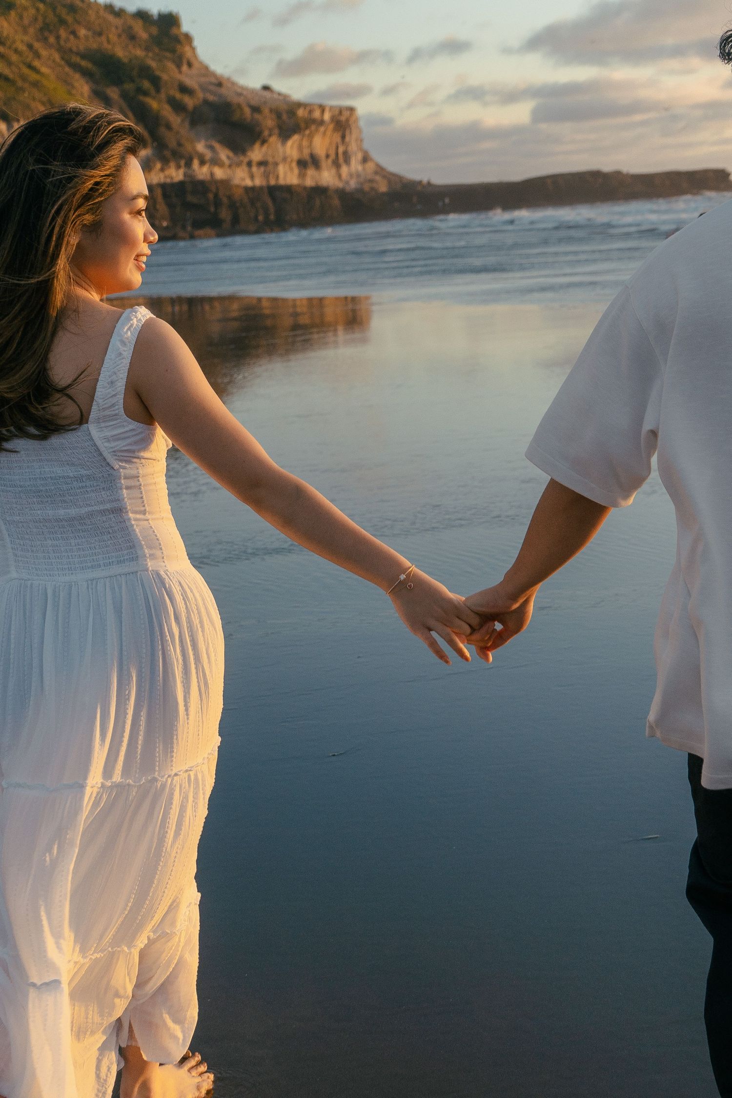 A couple photoshoot session during a magical sunset at Muriwai Beach by YM Photography.