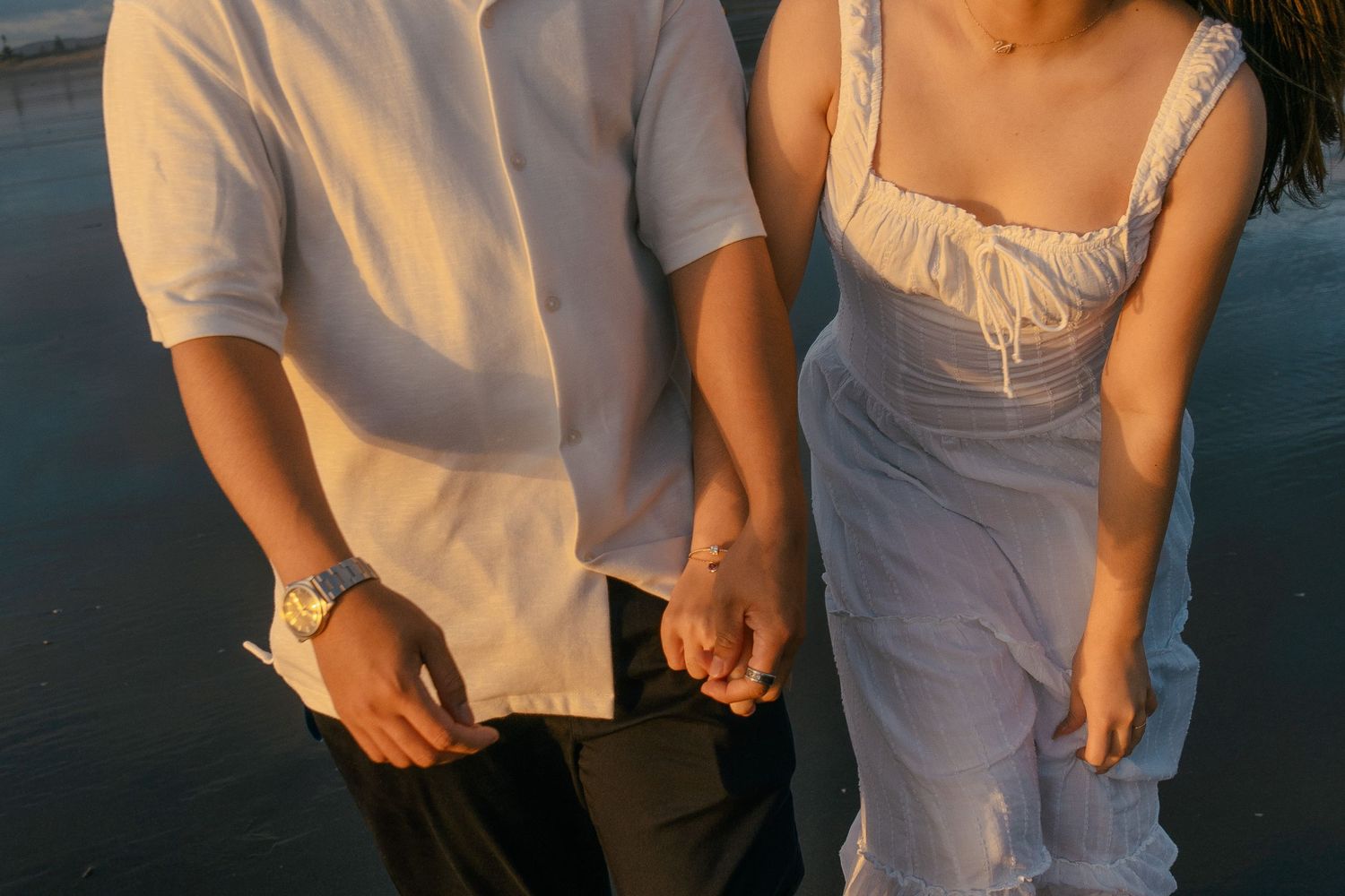 A couple photoshoot session during a magical sunset at Muriwai Beach by YM Photography.
