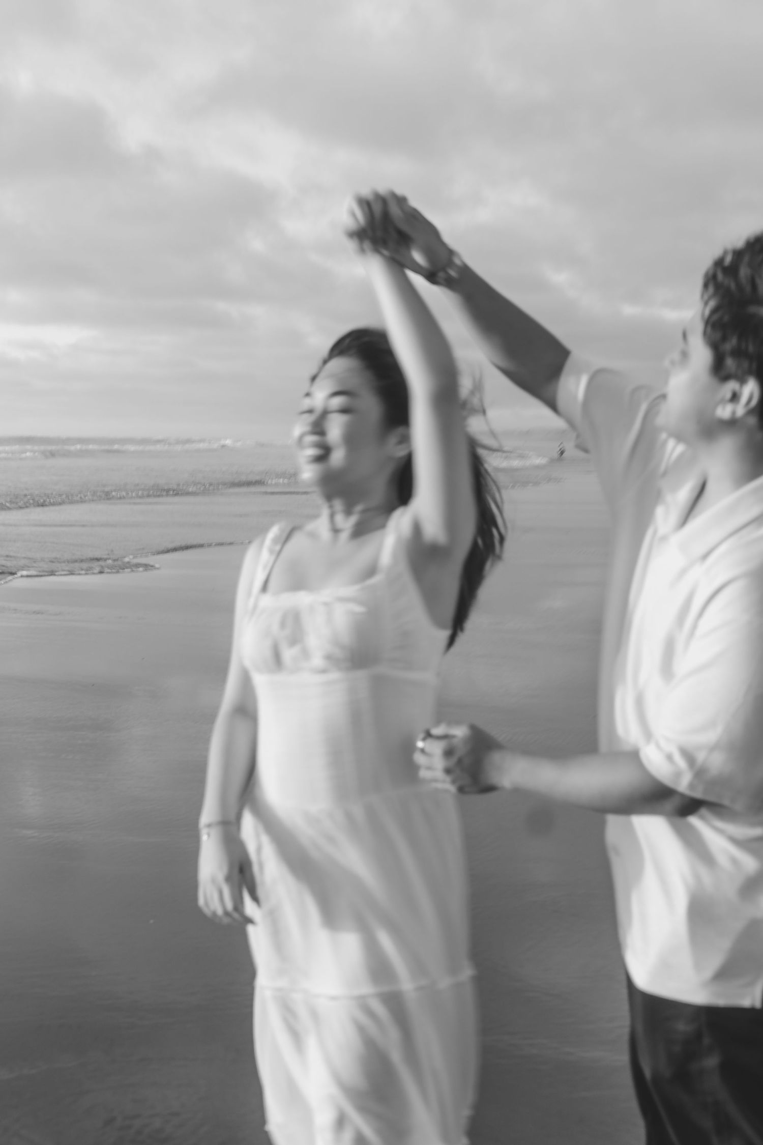 A couple photoshoot session during a magical sunset at Muriwai Beach by YM Photography.