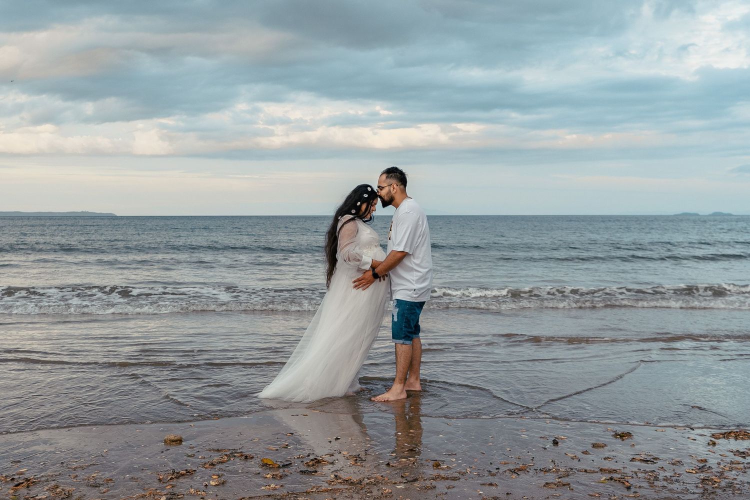 A gorgeous maternity shoot during sunset at Long Bay Beach, Auckland by YM Photography. White, flowy maternity dress used from Shein.