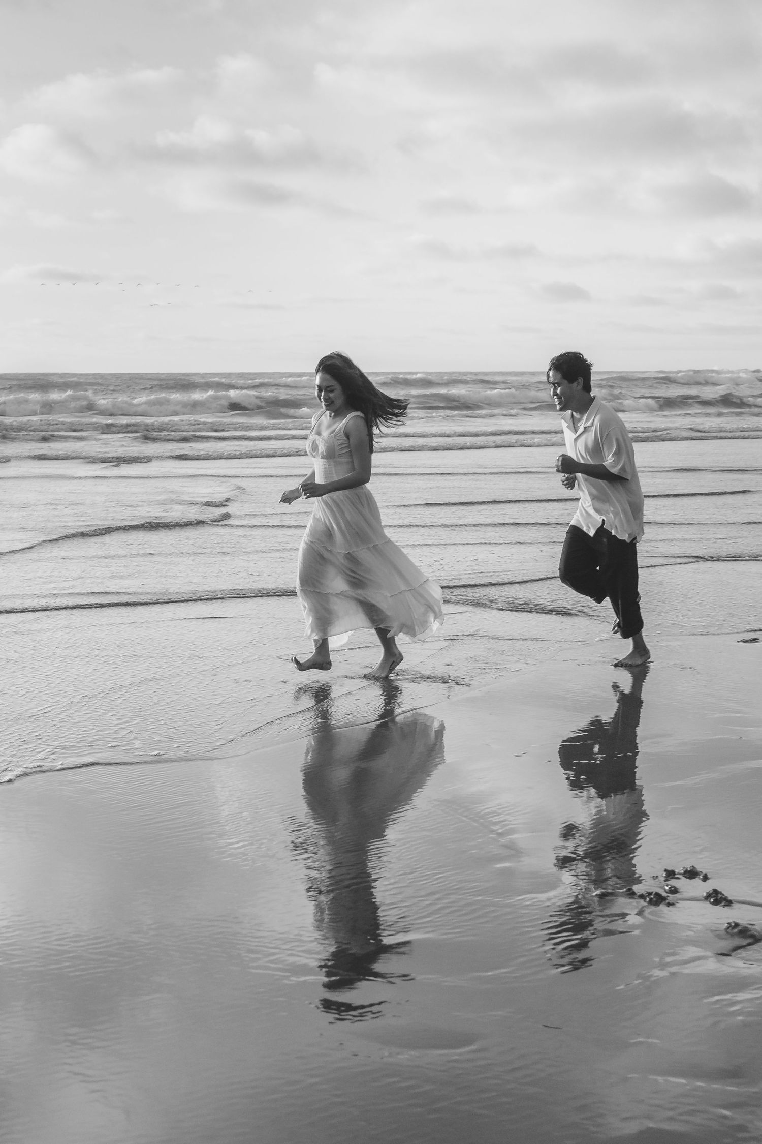 A couple photoshoot session during a magical sunset at Muriwai Beach by YM Photography.