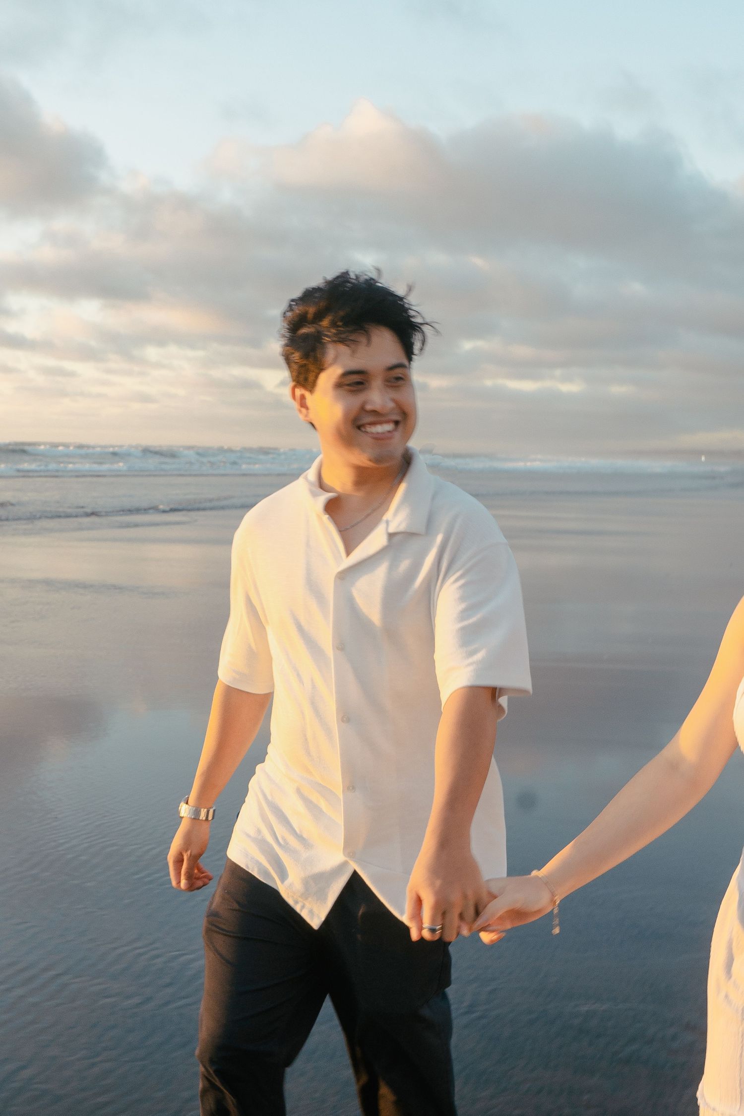 A couple photoshoot session during a magical sunset at Muriwai Beach by YM Photography.