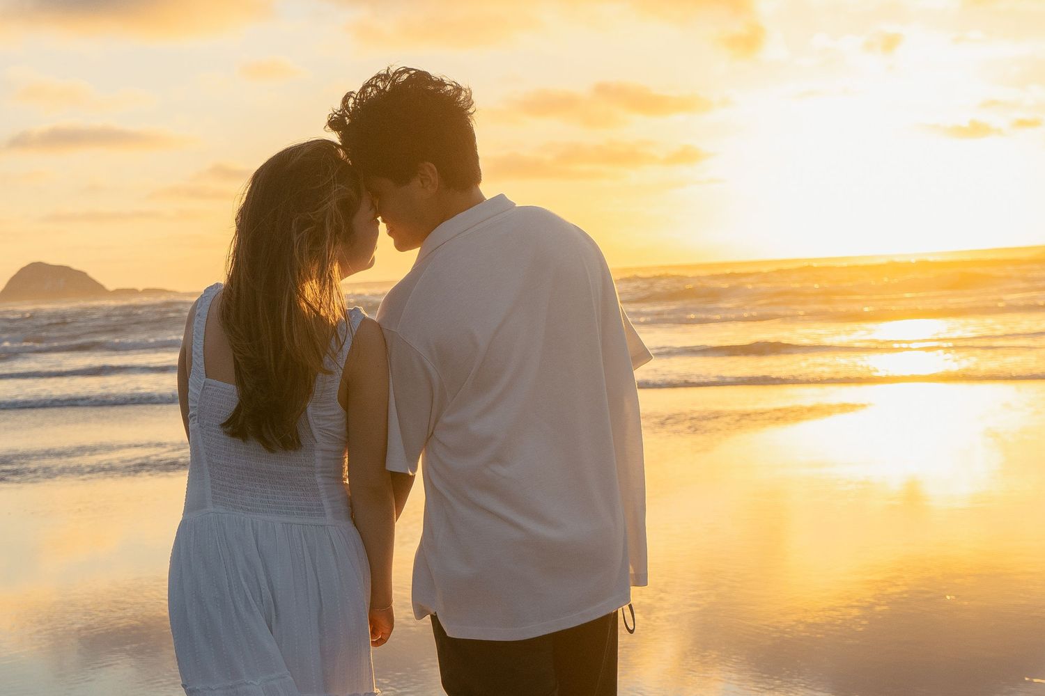 A couple photoshoot session during a magical sunset at Muriwai Beach by YM Photography.