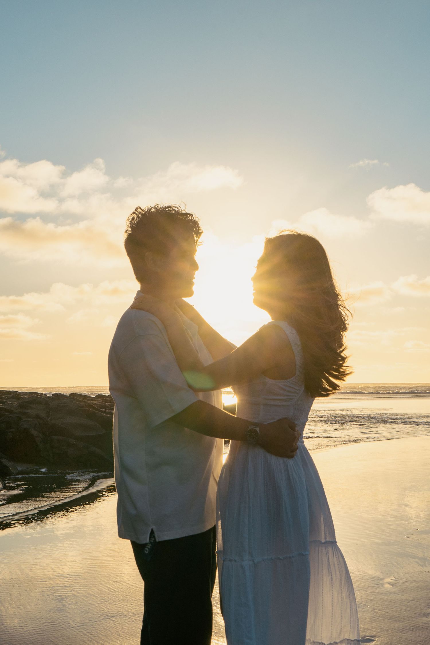 A couple photoshoot session during a magical sunset at Muriwai Beach by YM Photography. Chasing sunsets